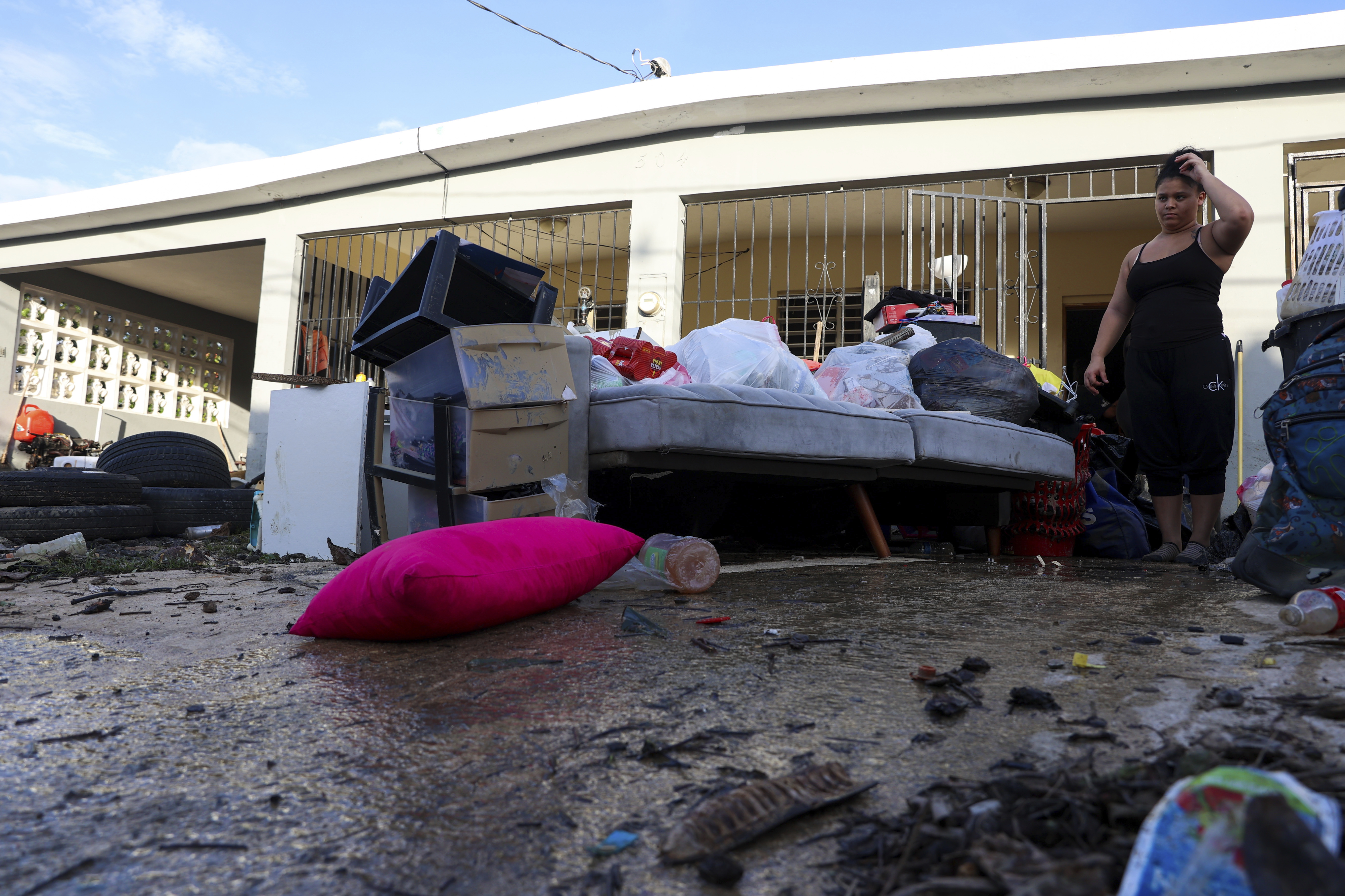 A woman looks at her water-damaged belongings after flooding caused by Hurricane Fiona tore through her home in Toa Baja, Puerto Rico, Tuesday. 