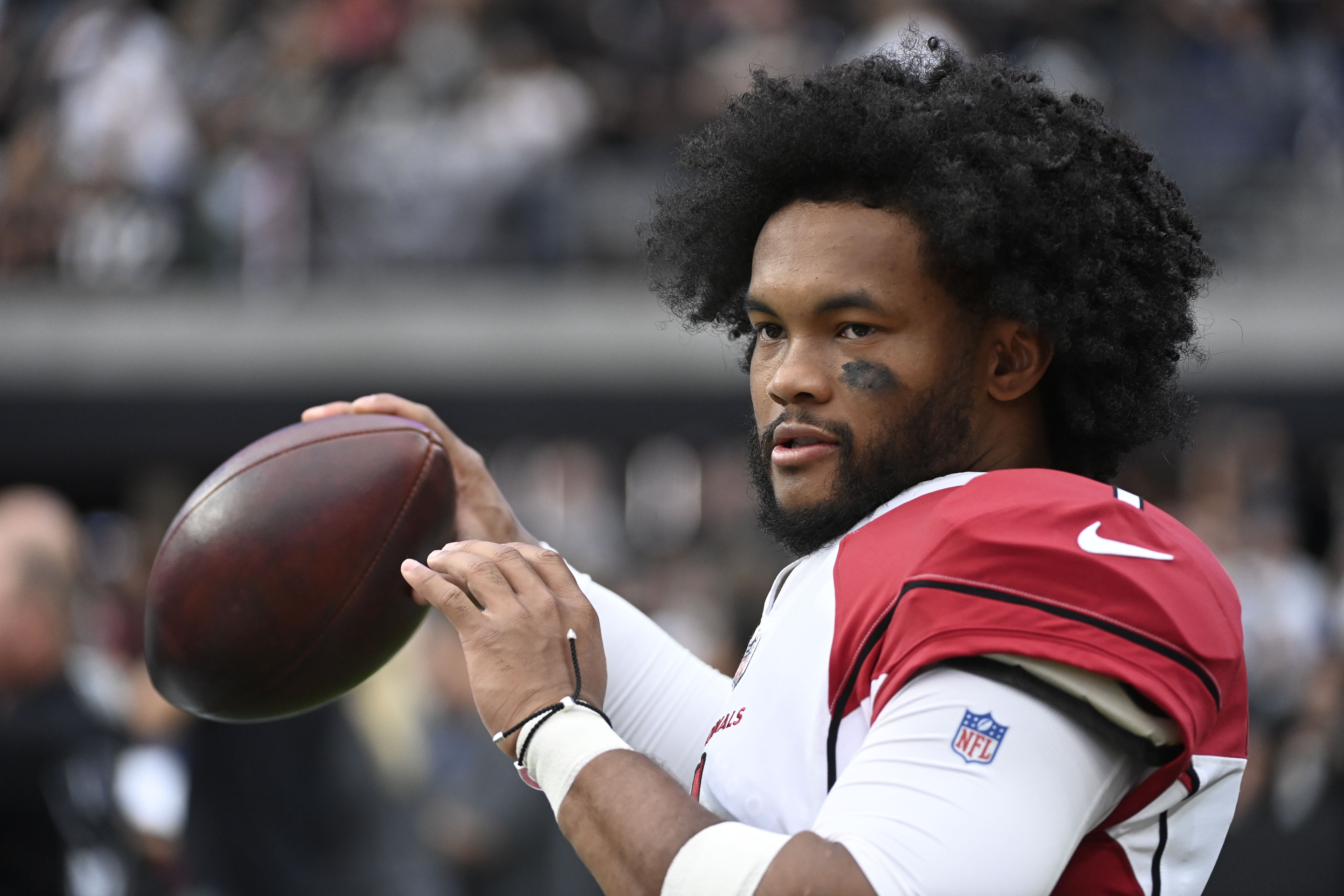 FILE - Arizona Cardinals quarterback Kyler Murray warms up on the sideline during the first half of an NFL football game against the Las Vegas Raiders Sunday, Sept. 18, 2022, in Las Vegas. Police in Las Vegas say they're investigating allegations that a fan struck Murray amid celebrations of Arizona's 29-23 overtime victory over the Raiders. 