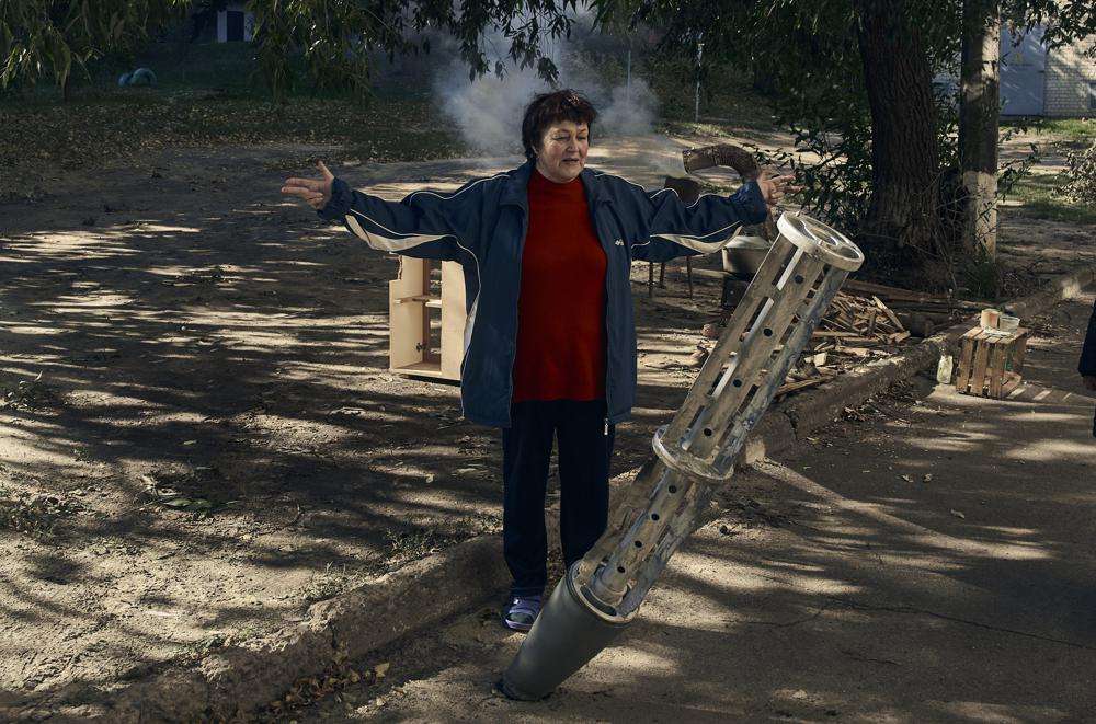 A local resident stands near a rocket fragment near her house in the recently retaken Kupiansk in the Kharkiv region, Ukraine, Wednesday.