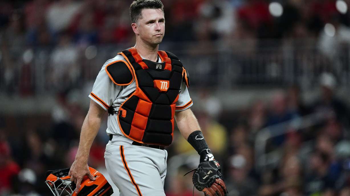 FILE - San Francisco Giants catcher Buster Posey walks on the field during the team's baseball game against the Atlanta Braves on Aug. 27, 2021, in Atlanta. The Giants announced Wednesday, Sept. 21, 2022, that the 35-year-old former catcher has joined the ownership group. Posey, while not announcing the percentage, said he bought in with his own money. He's also joining the six-person board of directors.