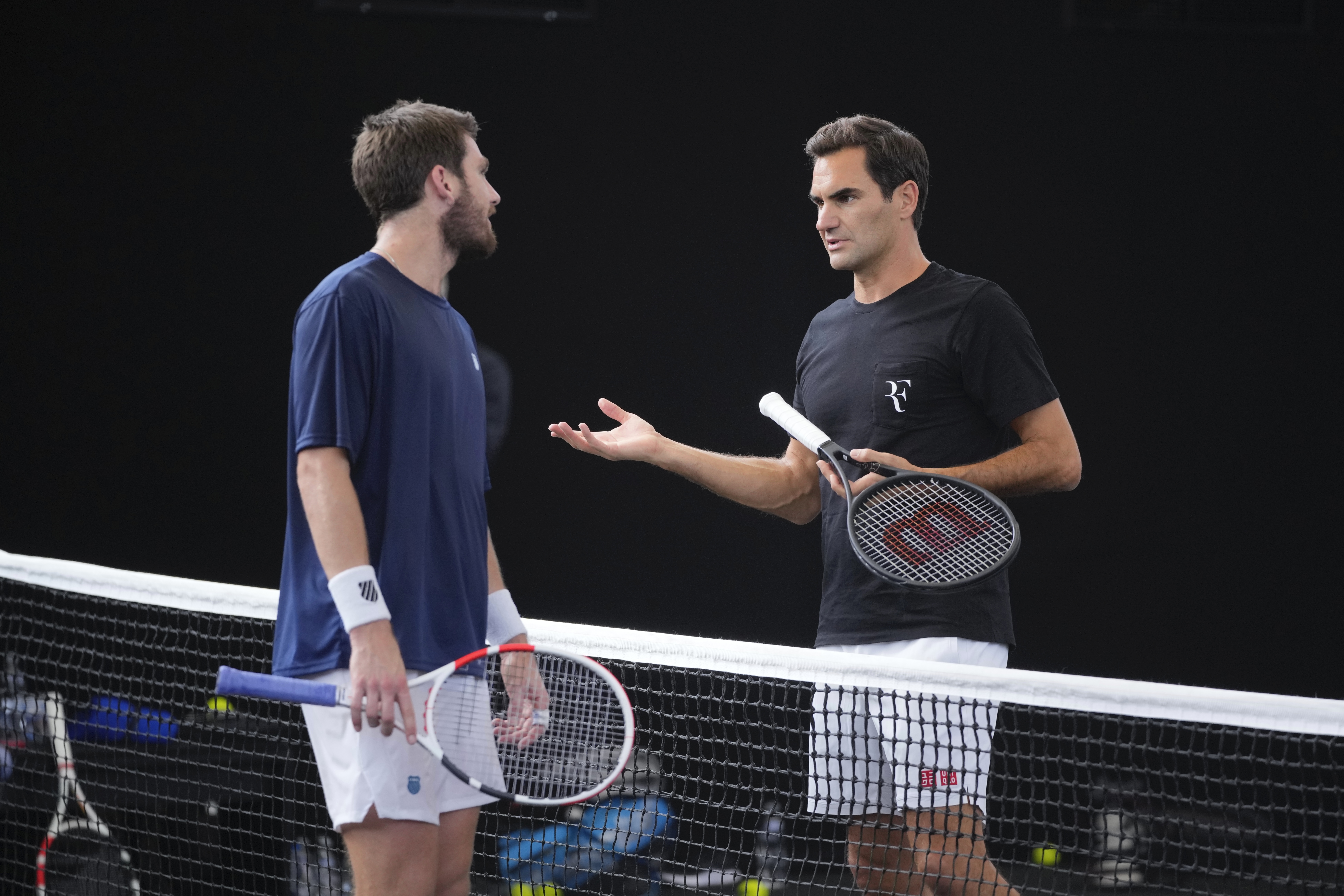 Switzerland's Roger Federer, right, chats with Cameron Norris, of Great Britain during a training session ahead of the Laver Cup tennis tournament at the O2 in London, Wednesday, Sept. 21, 2022. Federer appeared earlier at a news conference to discuss his retirement from professional tennis at age 41 after a series of knee operations. He will close his career with a doubles match at the Laver Cup on Friday. 