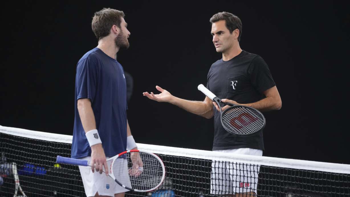 Switzerland's Roger Federer, right, chats with Cameron Norris, of Great Britain during a training session ahead of the Laver Cup tennis tournament at the O2 in London, Wednesday, Sept. 21, 2022. Federer appeared earlier at a news conference to discuss his retirement from professional tennis at age 41 after a series of knee operations. He will close his career with a doubles match at the Laver Cup on Friday.