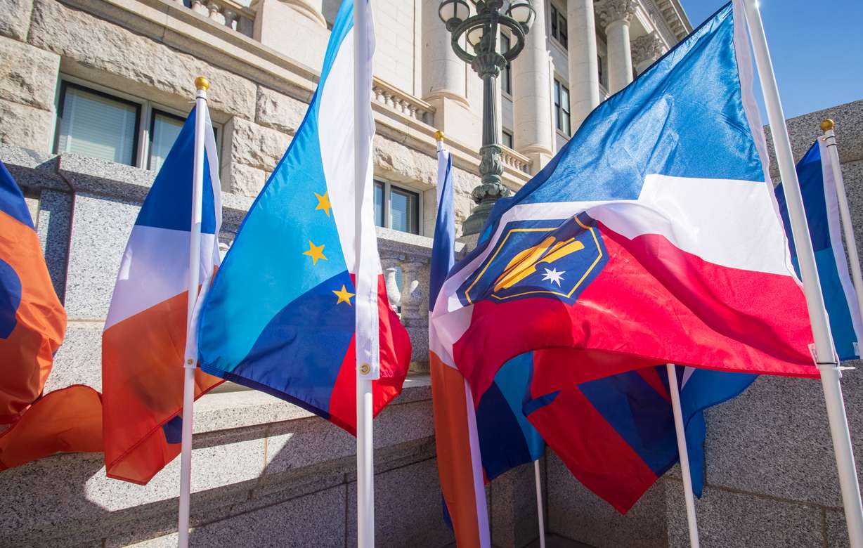 Some of the 20 semifinalist state flag designs picked by the Utah State Flag Task Force and a design committee fly outside of the Utah Capitol Thursday morning.