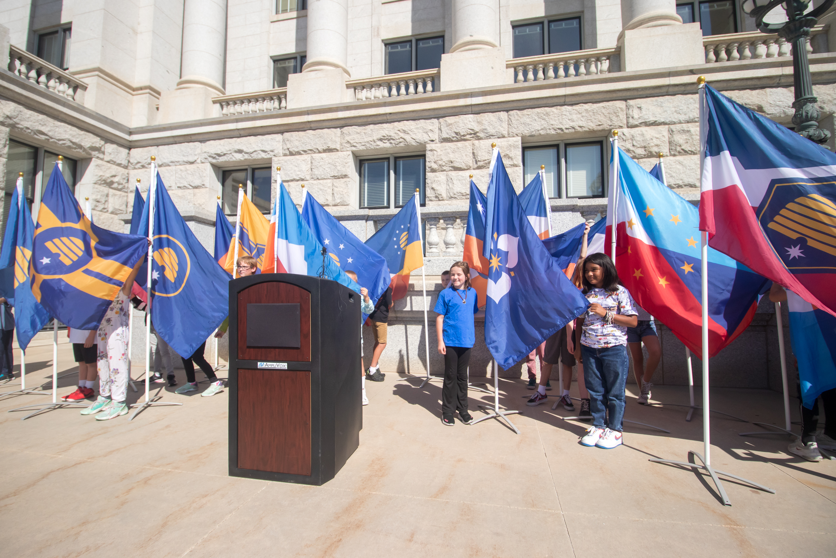 Students from a fourth grade class at Layton's Ellison Park Elementary School display the 20 semifinalists for a new Utah state flag during an event at the Utah Capitol on Thursday morning. The flags will remain on display at the Utah Capitol through Oct. 5.