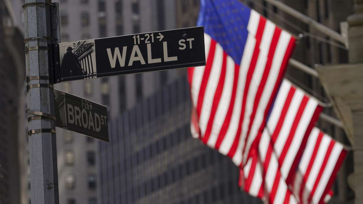 American flags fly outside the New York Stock Exchange, Friday, in New York. Markets sold off around the world on mounting signs the global economy is weakening just as central banks raise the pressure even more with additional hikes to interest rates.