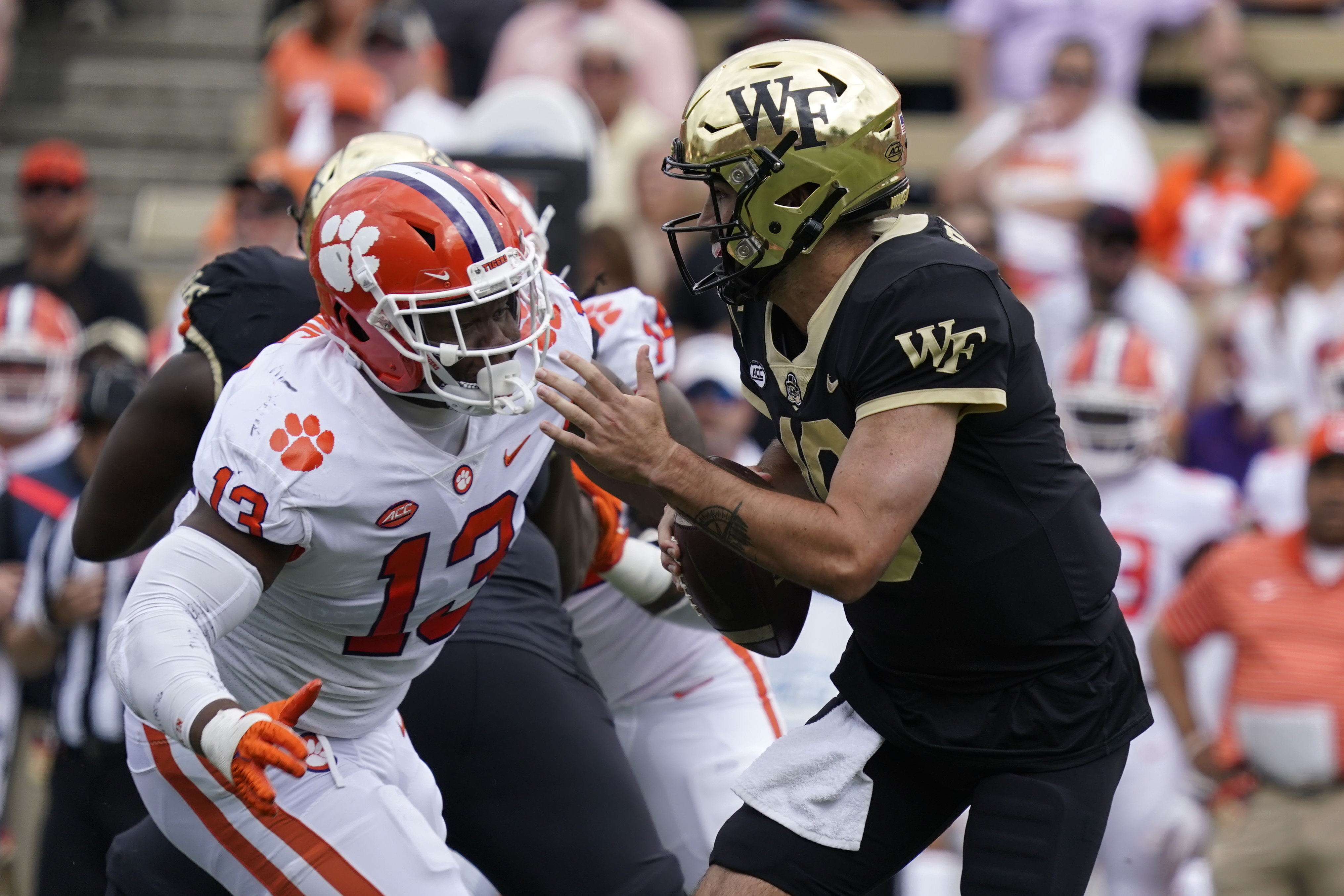 Wake Forest quarterback Sam Hartman (10) looks to pass as Clemson defensive tackle Tyler Davis (13) defends during the first half of an NCAA college football game in Winston-Salem, N.C., Saturday, Sept. 24, 2022. 
