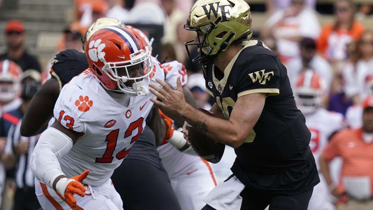 Wake Forest quarterback Sam Hartman (10) looks to pass as Clemson defensive tackle Tyler Davis (13) defends during the first half of an NCAA college football game in Winston-Salem, N.C., Saturday, Sept. 24, 2022.