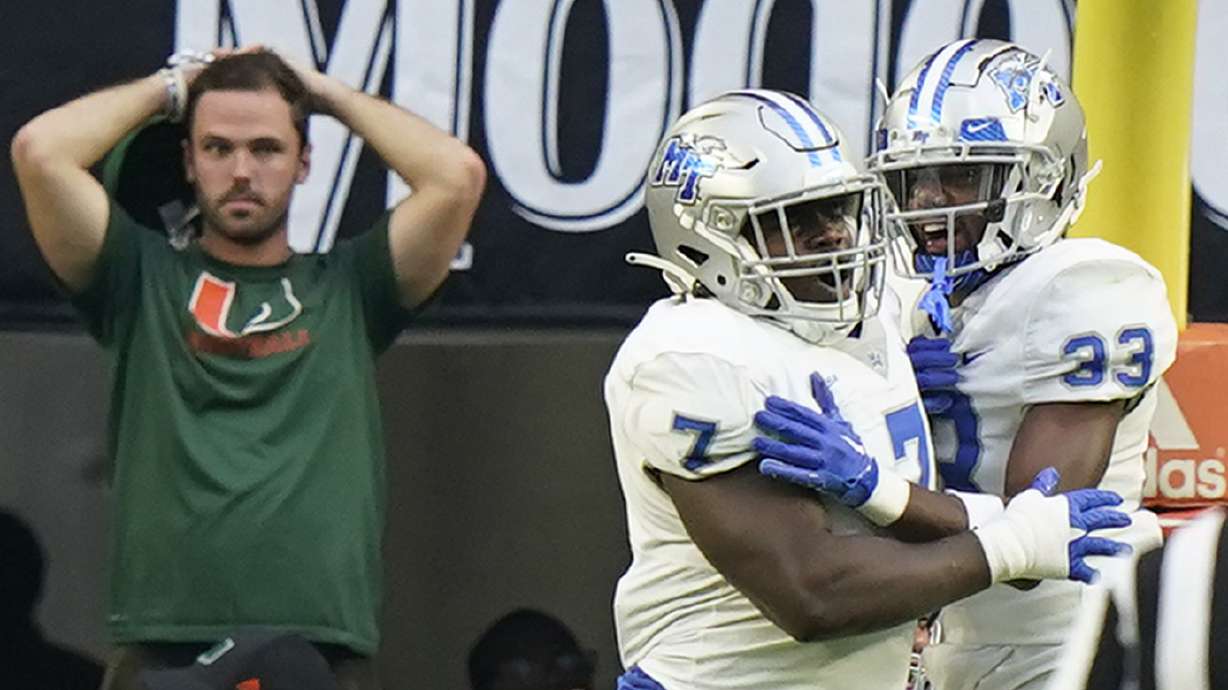 Middle Tennessee defensive tackle Zaylin Wood (7) celebrates with cornerback Decorian Patterson (33) after Wood intercepted the ball and scored during the first half of an NCAA college football game against Miami, Saturday, Sept. 24, 2022, in Miami Gardens, Fla.