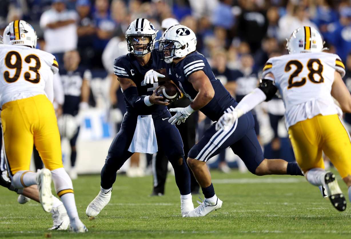 Brigham Young quarterback Jaren Hall (3) hands the ball off to Brigham Young running back Lopini Katoa (4) as BYU and Wyoming play at LaVell Edwards Stadium in Provo on Saturday, Sept. 24, 2022.