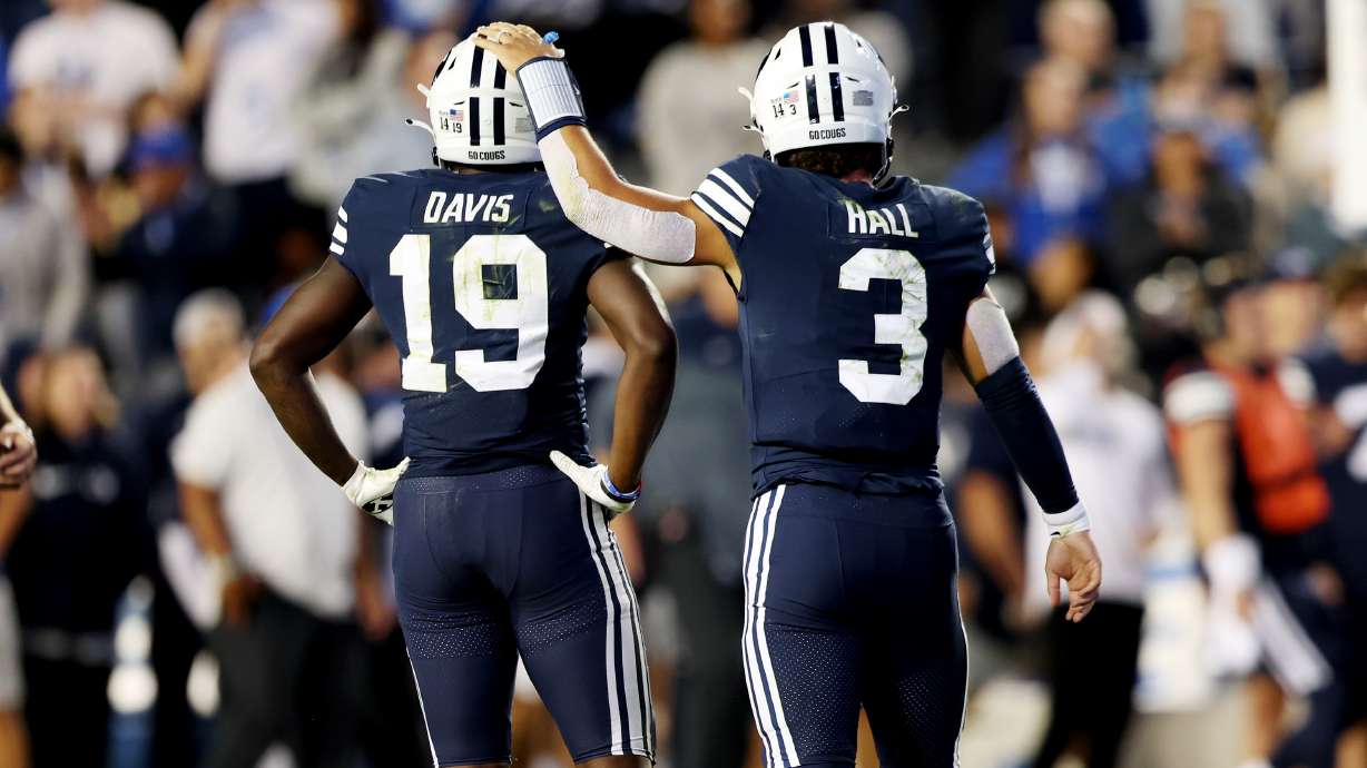 Brigham Young Cougars quarterback Jaren Hall (3) pats teammate Brigham Young Cougars running back Miles Davis (19) on the head as BYU and Wyoming play at LaVell Edwards Stadium in Provo on Saturday, Sept. 24, 2022. BYU won 38-24.