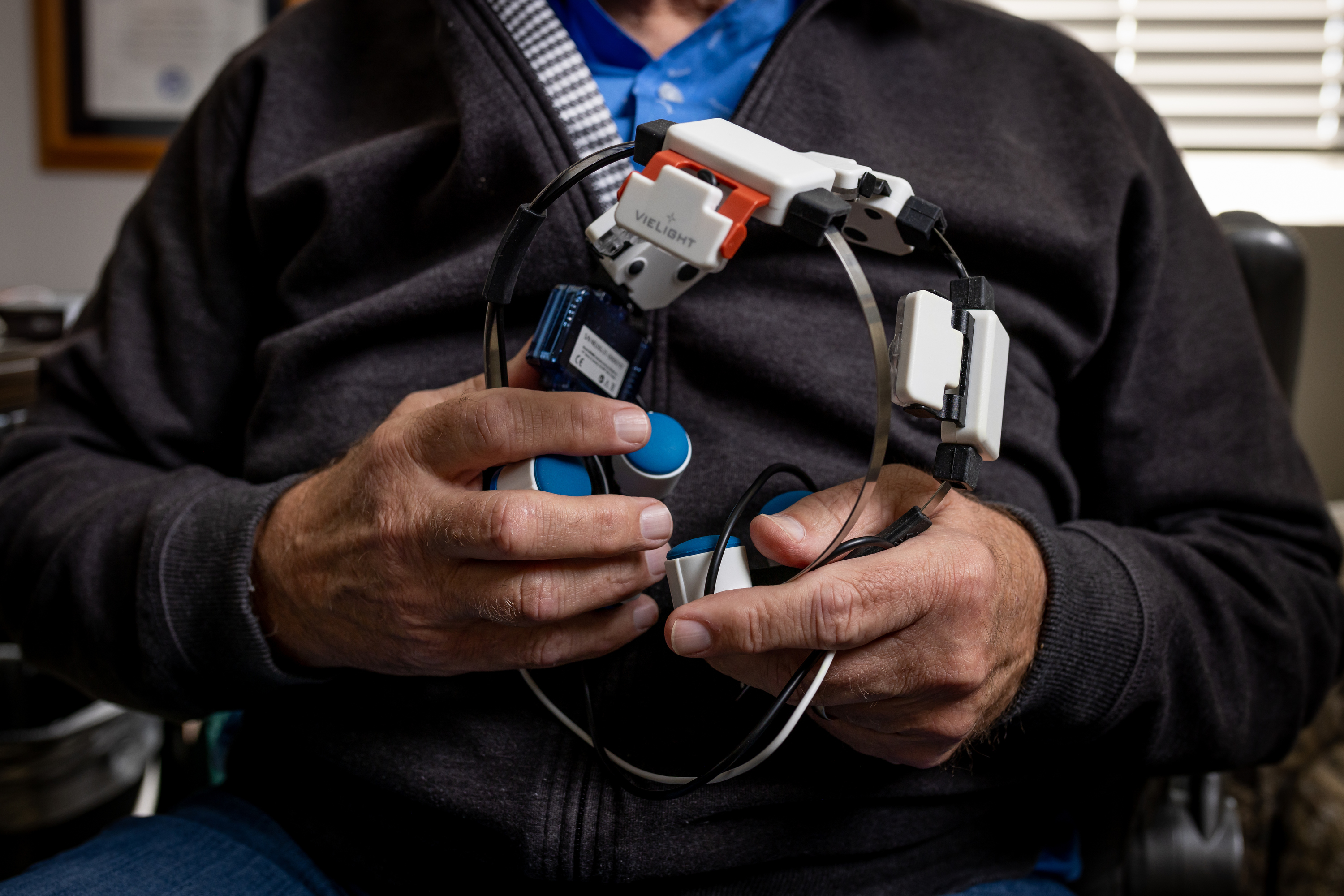 Former Brigham Young University football player Larry Carr poses for a photo with a Vielight Neuro Gamma headset at his home in Saratoga Springs on Saturday. Carr uses the headset to treat the effects of repetitive head injuries sustained during his football career, and is part of a study investigating the effectiveness of the treatment at the University of Utah.