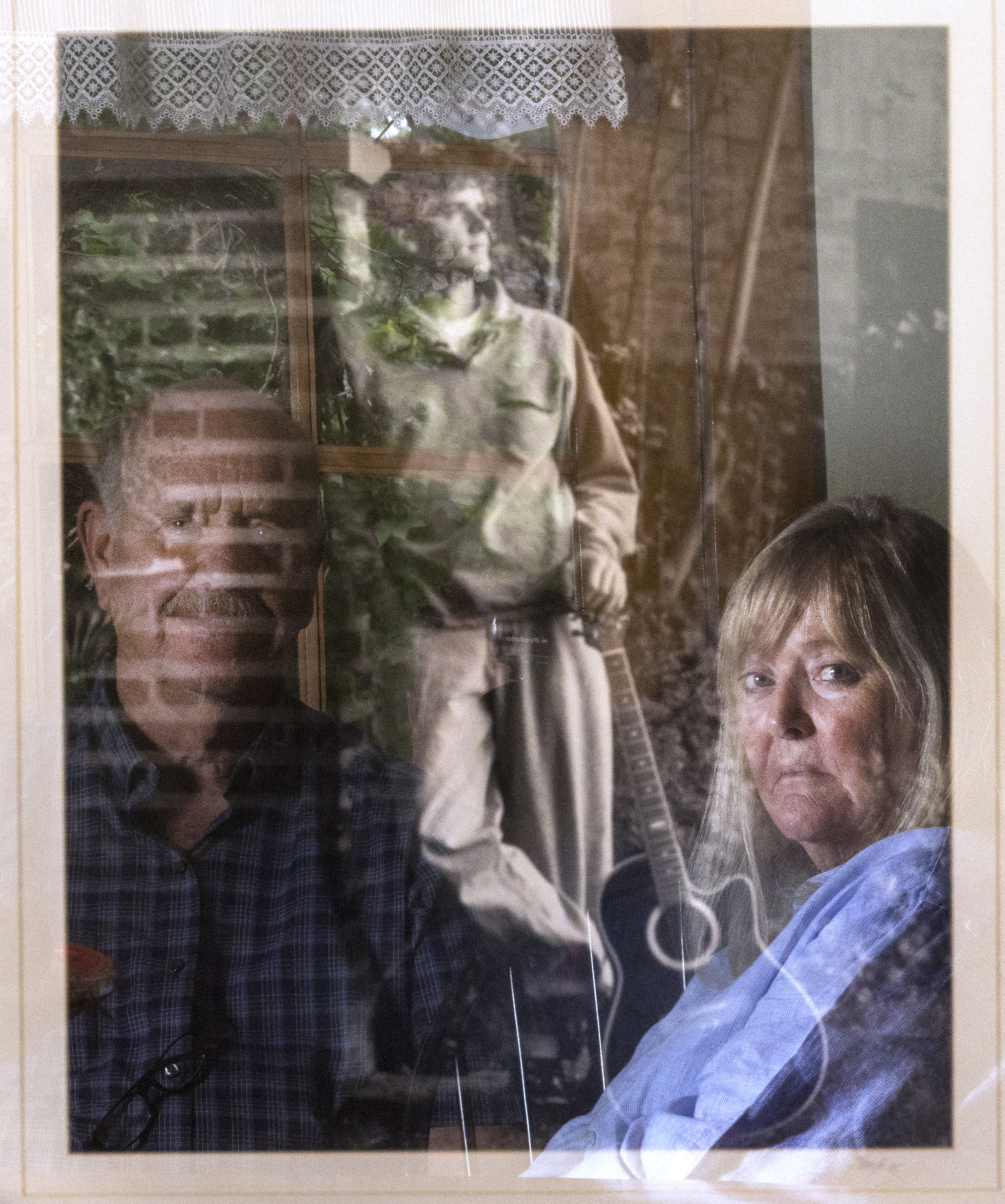 Ron and Sy Snarr are reflected in a photo of their son, Zachary Snarr, on Friday, Aug. 19, 2022. Zachary was killed by Jorge Benvenuto in August 1996.