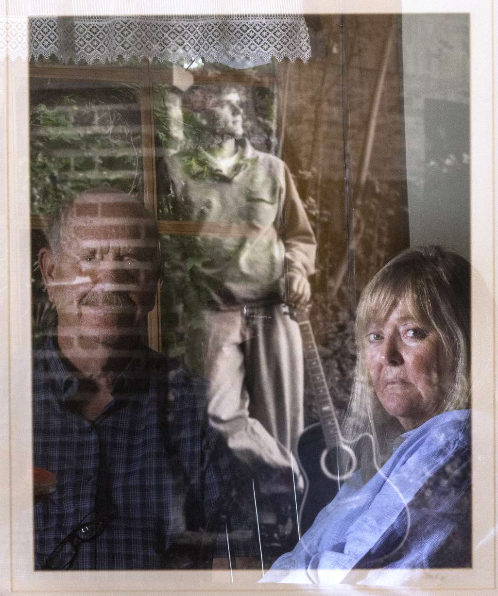 Ron and Sy Snarr are reflected in a photo of their son, Zachary Snarr, on Friday, Aug. 19, 2022. Zachary was killed by Jorge Benvenuto in August 1996.