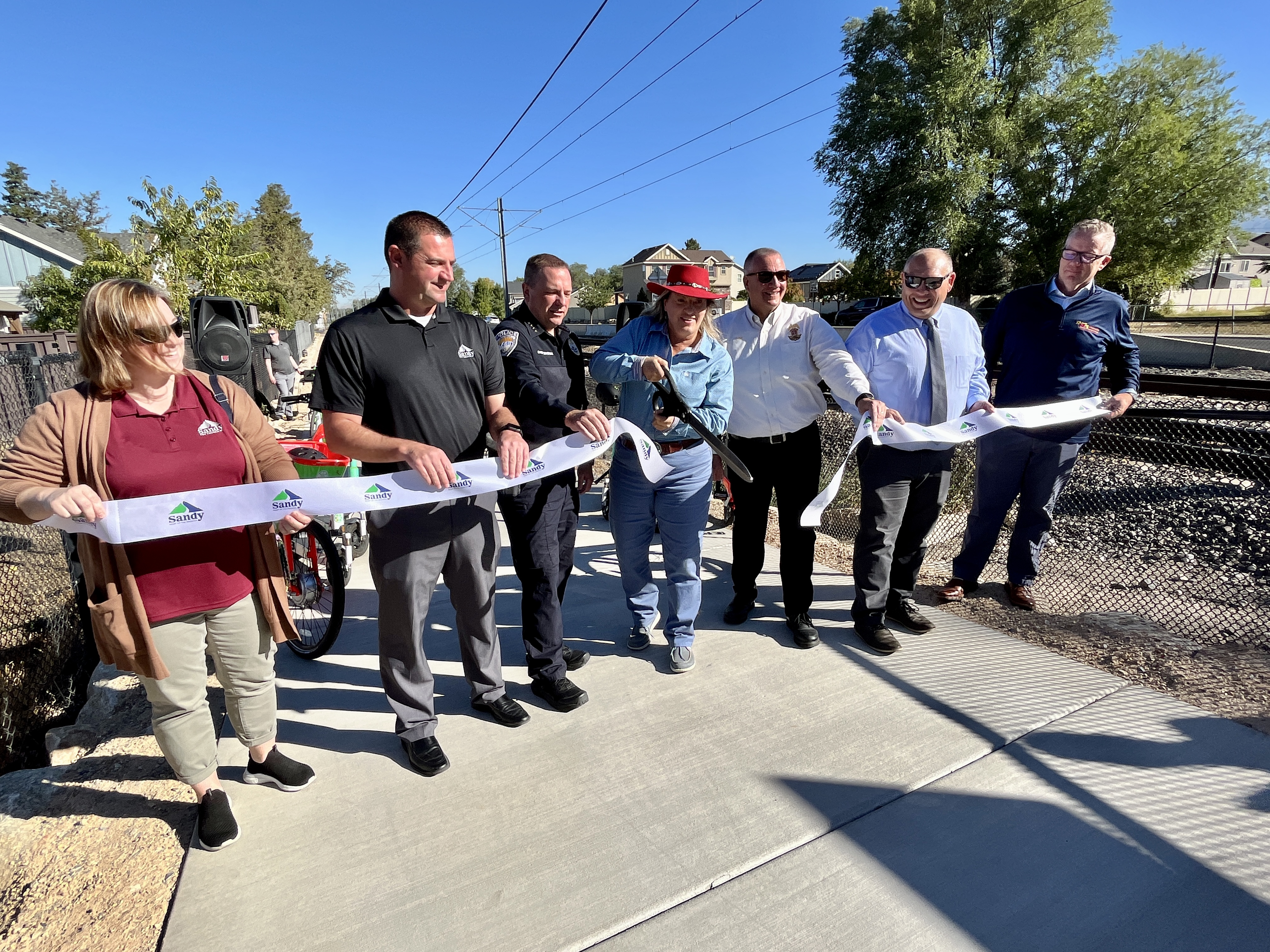 Sandy Mayor Monica Zoltanski cuts a ribbon to open the final section of the Porter Rockwell Trail in Sandy. It's a small extension of the trail north of its previous terminus north of Pioneer Avenue.