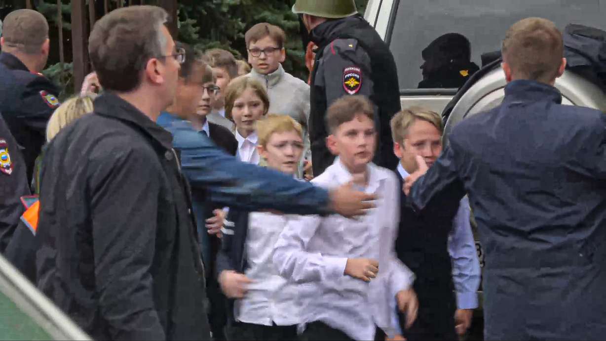 In this image taken from video, school children run from the scene of a shooting at school No. 88 in Izhevsk, Russia, Monday. Authorities say a gunman has killed 17 people Monday and wounded 24 others in a school in central Russia. According to officials, 11 children were among those killed.