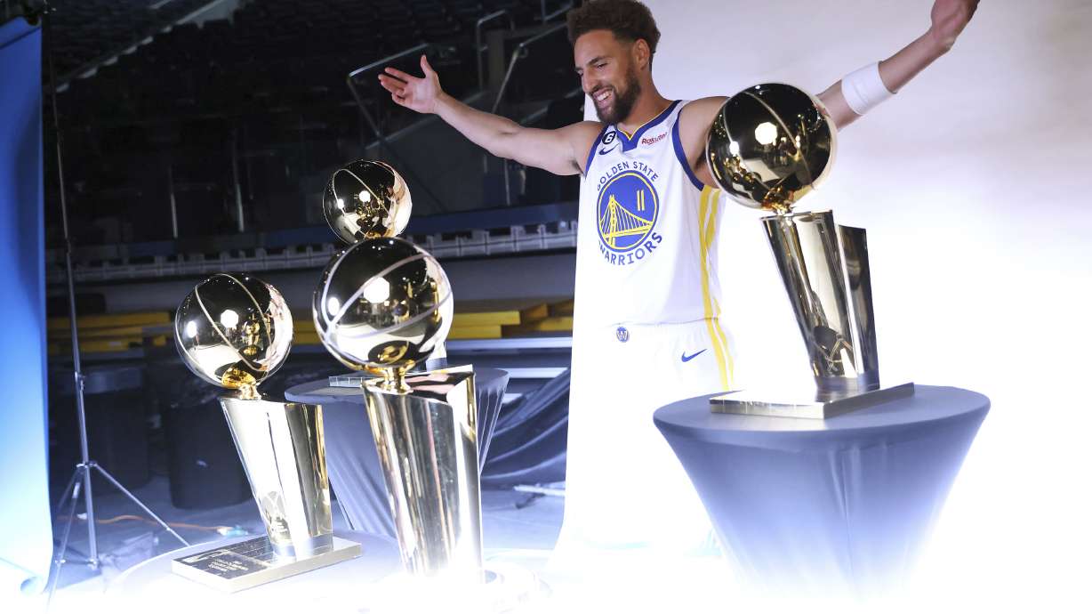 Golden State Warriors' Klay Thompson poses with four Larry O'Brien trophies during Media Day at Chase Center in San Francisco, Sunday, Sept. 25, 2022.