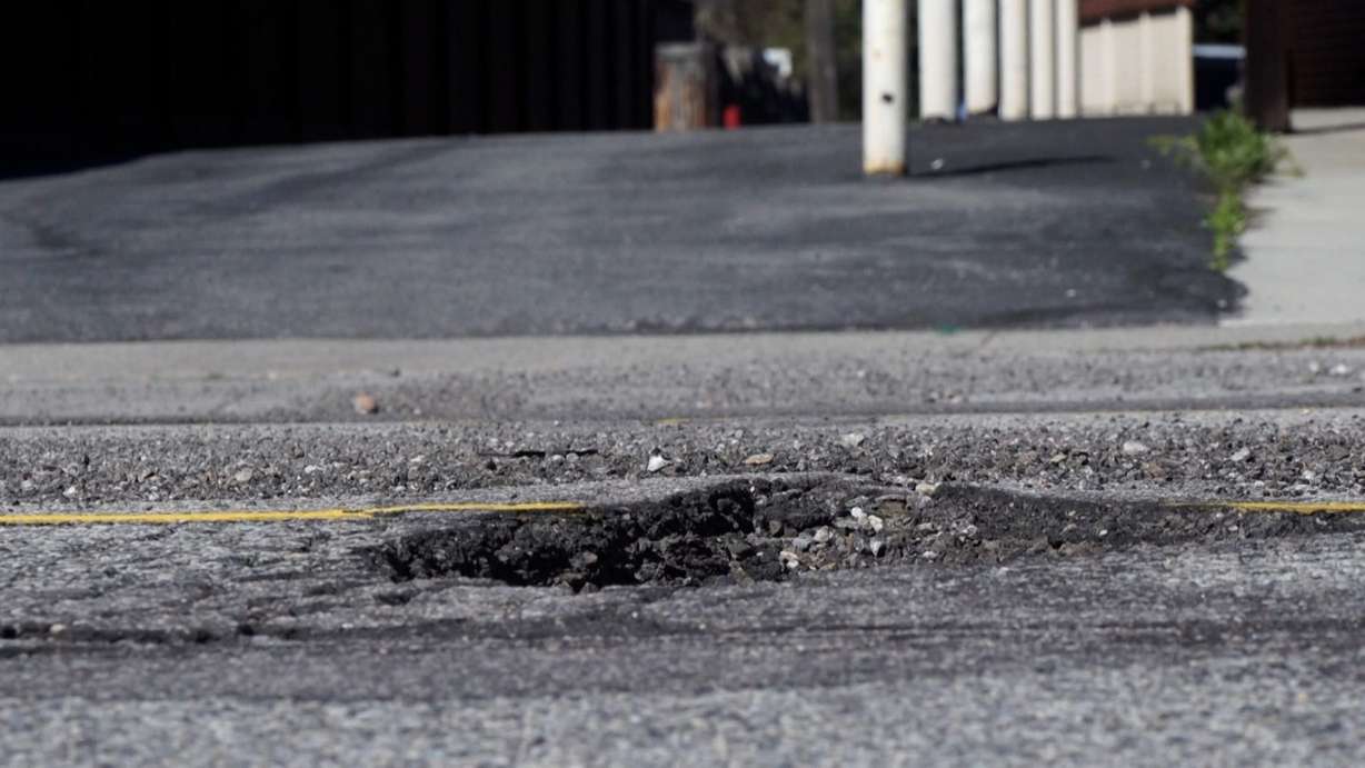 A pothole is shown in a Utah road. Local governments aren’t automatically immune from paying for pothole damage, but claimants have to prove the government knew about the pothole beforehand and failed to fix it.