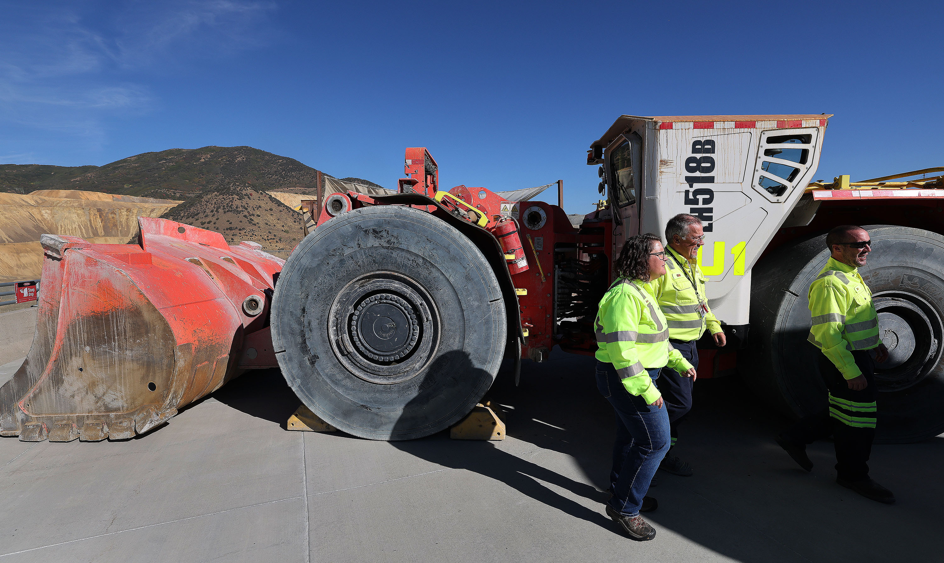 Rio Tinto employees walk past a battery-operated underground mining load haul dump loader at the Kennecott Copper Mine near Herriman on Tuesday. Rio Tinto announced it will resume underground mining at the mine after more than a century.