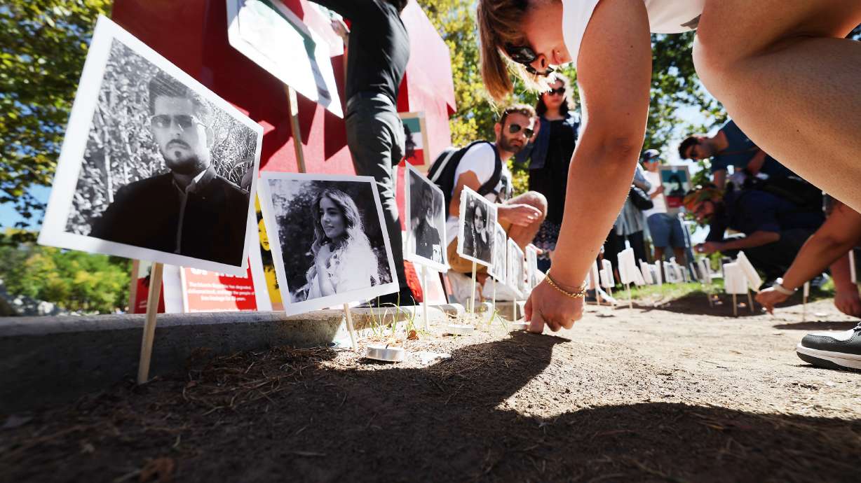 University of Utah students post photos of people who have died in a crackdown by the Iranian government during a protest outside of the A. Ray Olpin Student Union in Salt Lake City on Tuesday, Sept. 27. Another protest was held on Saturday with members marching to the state Capitol.