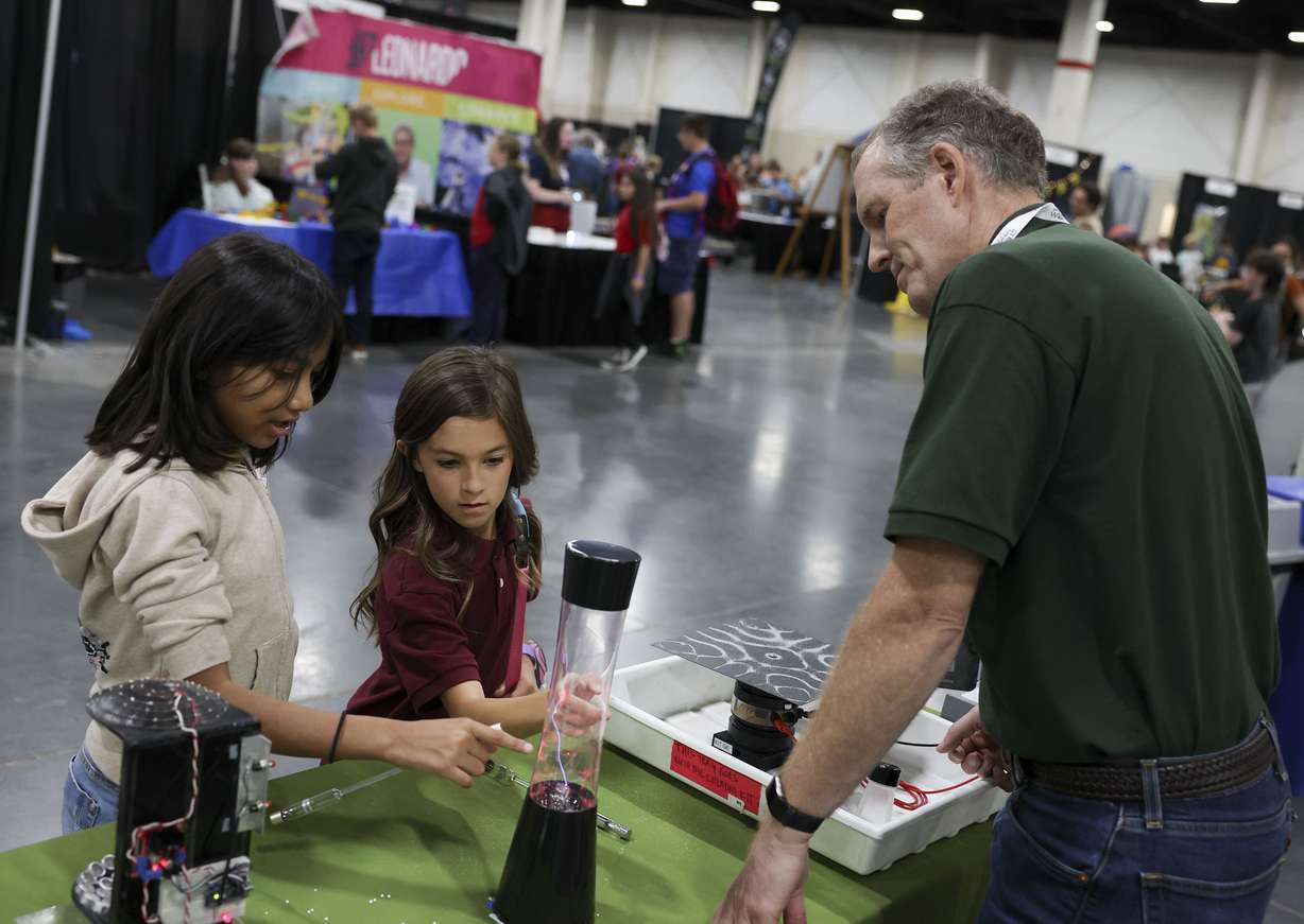 Dulce Ramos, a fourth grader at South Kearns Elementary, and Charleigh Kranendonk, a fifth grader at Layton Christian Academy, learn about physics from UVU physics professor Jospeh Jensen at the 8th annual STEM Fest at the Mountain America Expo Center in Sandy on Tuesday.