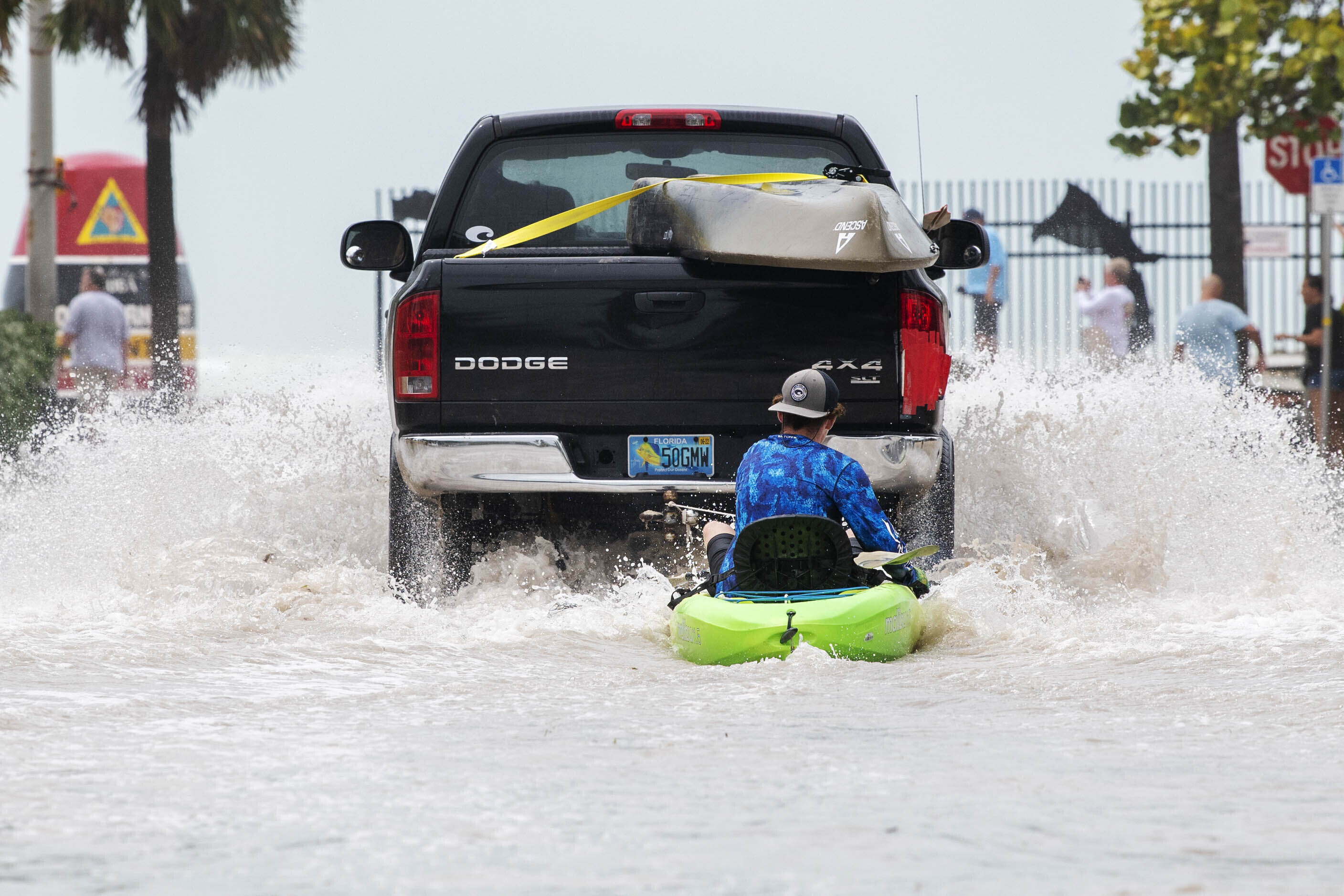 A truck pulls a man on a kayak on a low-lying road after flooding in the aftermath of Hurricane Ian, in Key West, Fla., Wednesday afternoon.