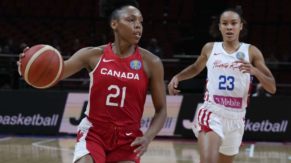 Canada's Nirra Fields, left, runs past Puerto Rico's Trinity San Antonio during their quarterfinal game at the women's Basketball World Cup in Sydney, Australia, Thursday, Sept. 29, 2022.