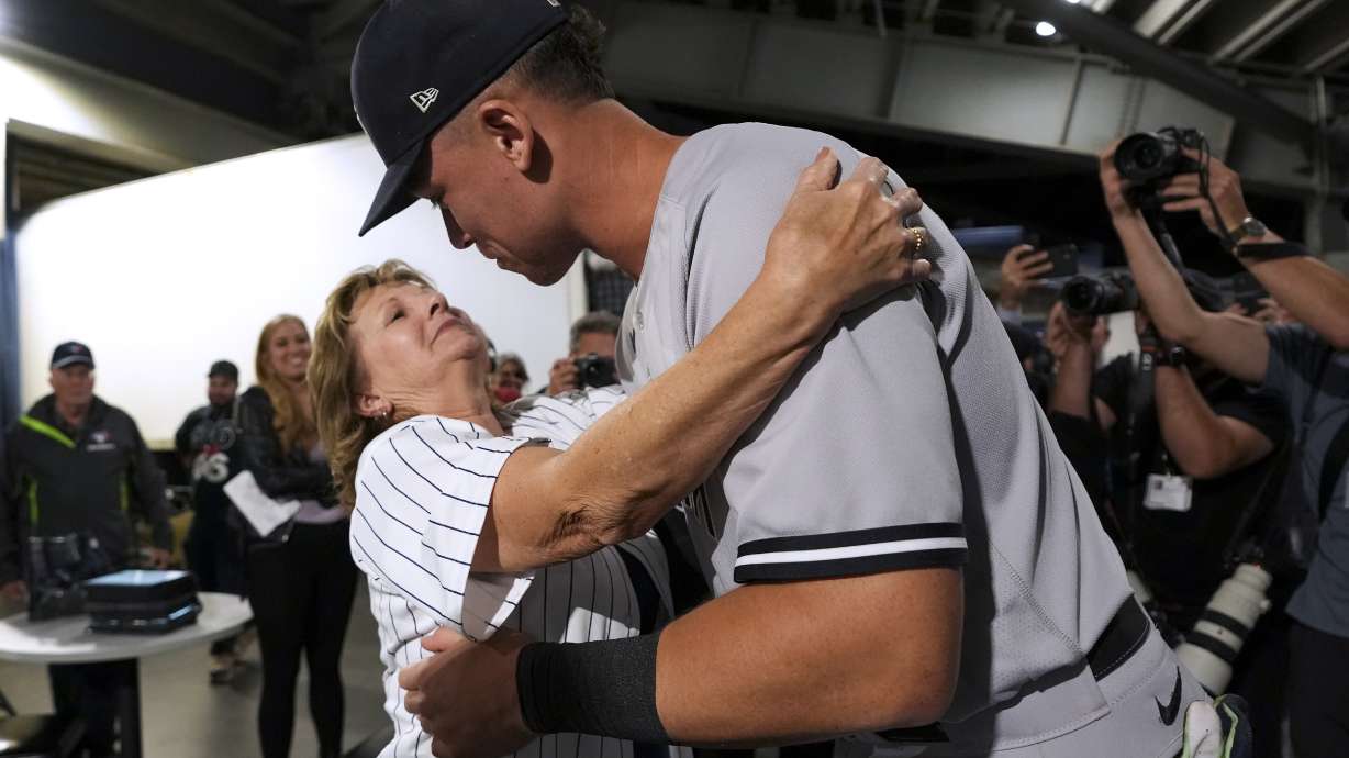 New York Yankees' Aaron Judge hugs his mother, Patty Judge, after the team's baseball game against the Toronto Blue Jays on Wednesday, Sept. 28, 2022, in Toronto. Judge hit his 61st home run of the season.