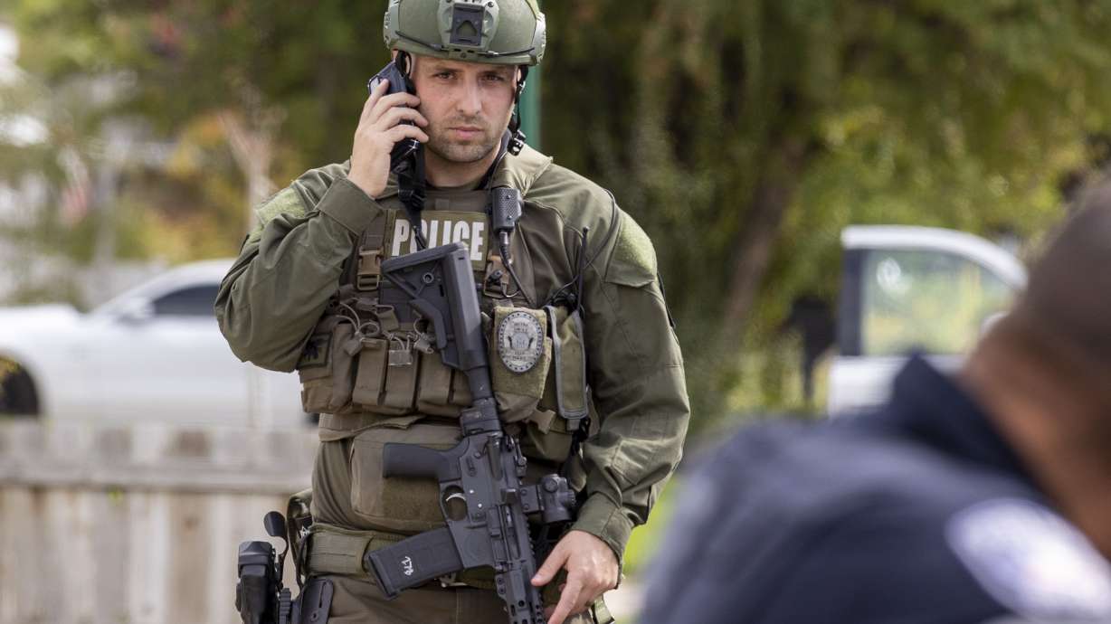 A SWAT officer walks while on the phone after a standoff in Orem on Thursday. A man was hospitalized on Thursday after a shootout with officers in Orem, police said.