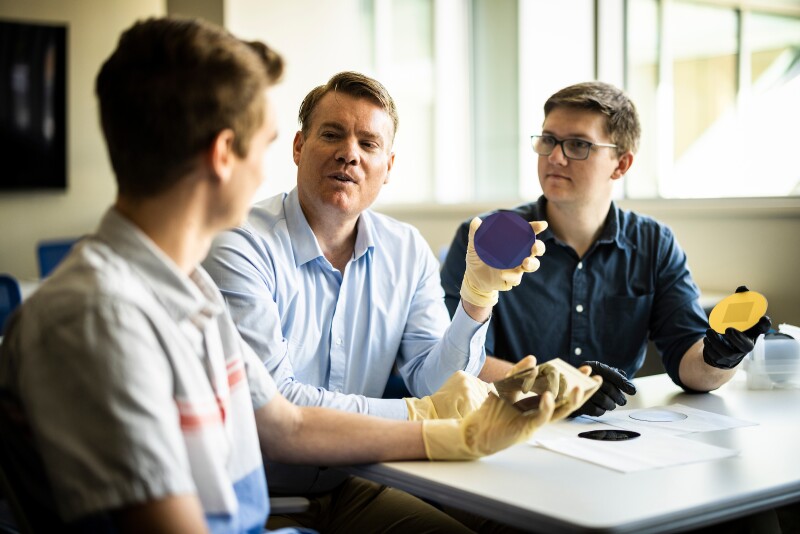 Carson Zeller, left, Aaron Hawkins and Ethan Belliston hold scripture they engraved onto thin silicon discs. They helped make the smallest Book of Mormon.