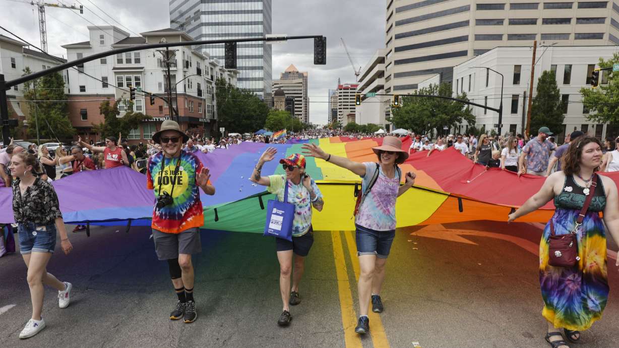 Volunteers hold a rainbow flag while marching in the Utah Pride Parade along 200 South in Salt Lake City on June 5. A new poll shows nearly three-fourths of Utahns say marriages between same-sex couples should be considered valid under the law.