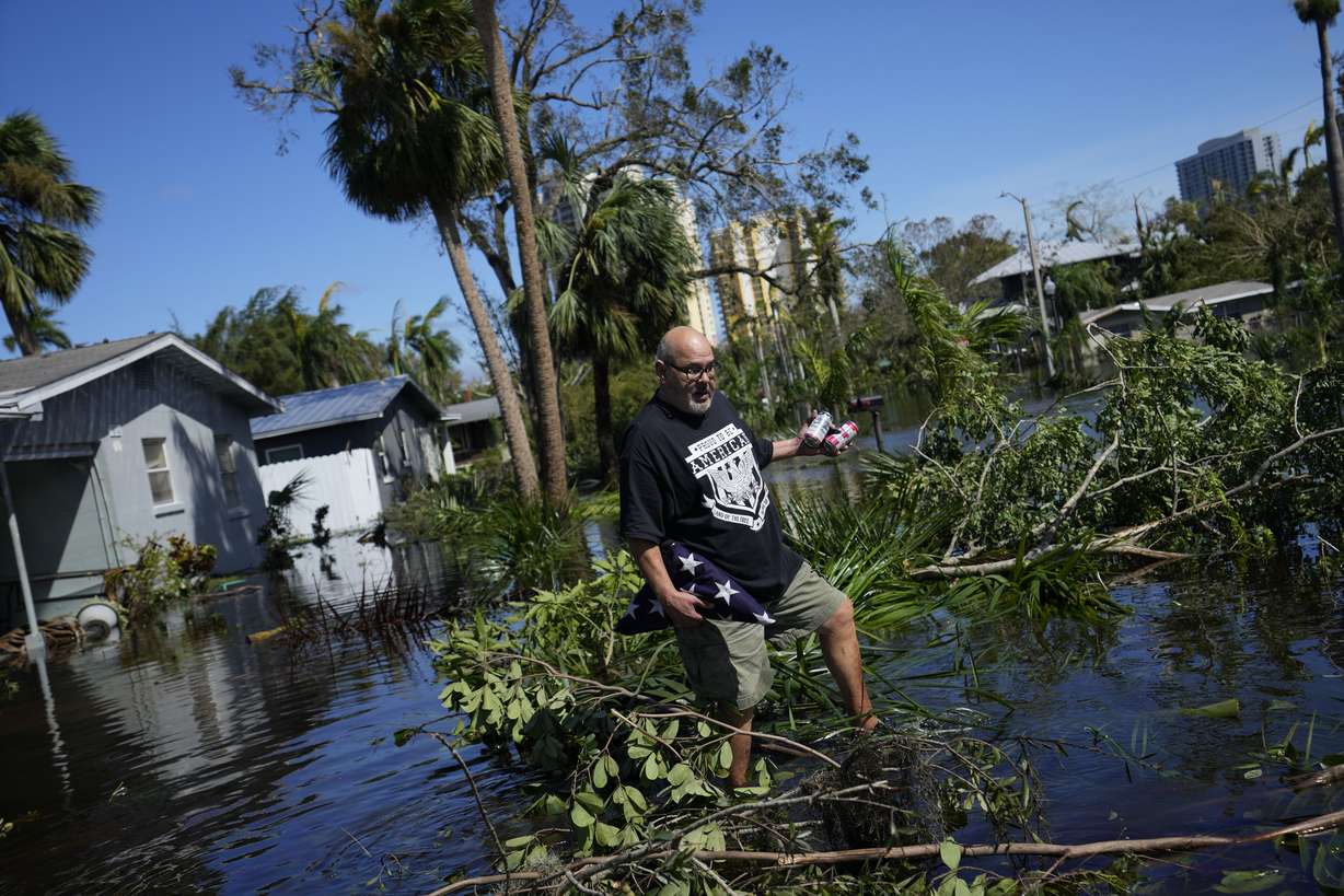 Retired marine Efrain Burgos Jr. recovers a lone personal item from a first visit to his flooded home, the American flag presented at the burial of his army veteran father, in Fort Myers, Fla. Thursday.