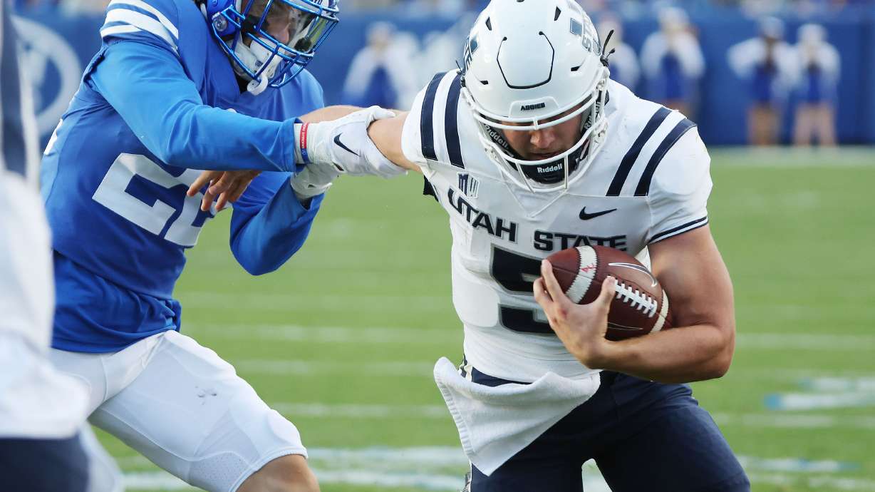 Utah State Aggies quarterback Cooper Legas (5) runs for a touchdown against BYU in Provo on Thursday, Sept. 29, 2022.