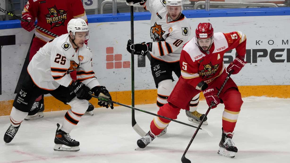 FILE - Kunlun Red Star's Ryan Sproul, right, of Canada, fifths for the puck with Amur's Radan Lenc, left, during the Kontinental Hockey League ice hockey match between Kunlun Red Star Beijing and Amur Khabarovsk in Mytishchi, just outside Moscow, Russia, on Nov. 15, 2021. North Americans playing in the Russia-based KHL have been put in a difficult position amid calls from the U.S and Canadian governments for them to leave the country because of the war in Ukraine.