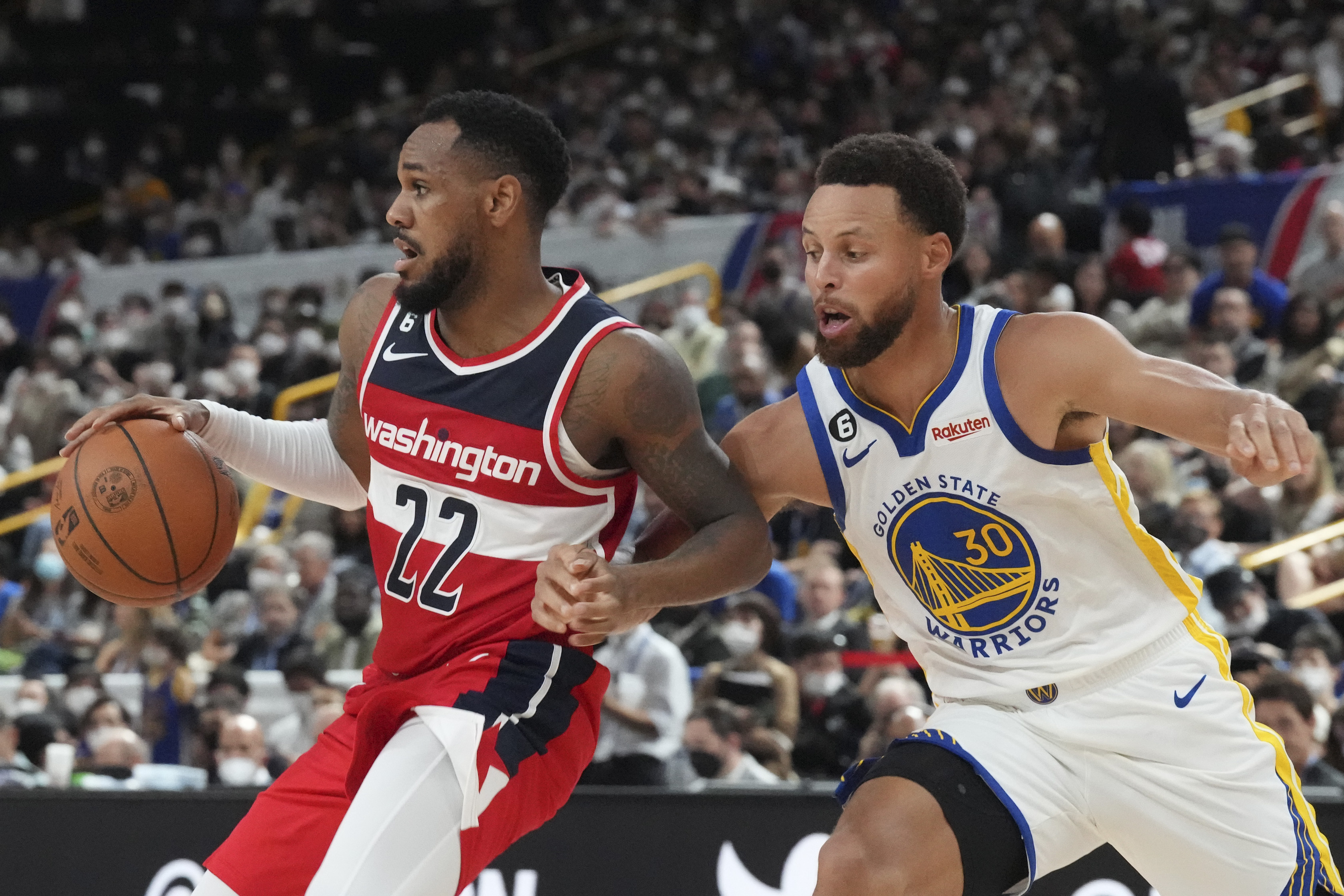 Washington Wizards' Monte Morris, left, plays against Golden State Warriors' Stephen Curry during their preseason NBA basketball game, Friday, Sept. 30, 2022, at Saitama Super Arena, in Saitama, north of Tokyo. 