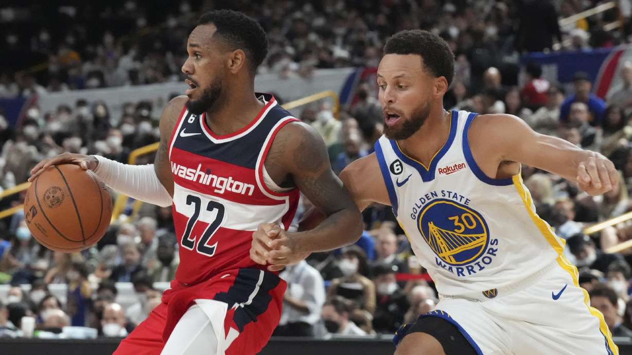 Washington Wizards' Monte Morris, left, plays against Golden State Warriors' Stephen Curry during their preseason NBA basketball game, Friday, Sept. 30, 2022, at Saitama Super Arena, in Saitama, north of Tokyo.