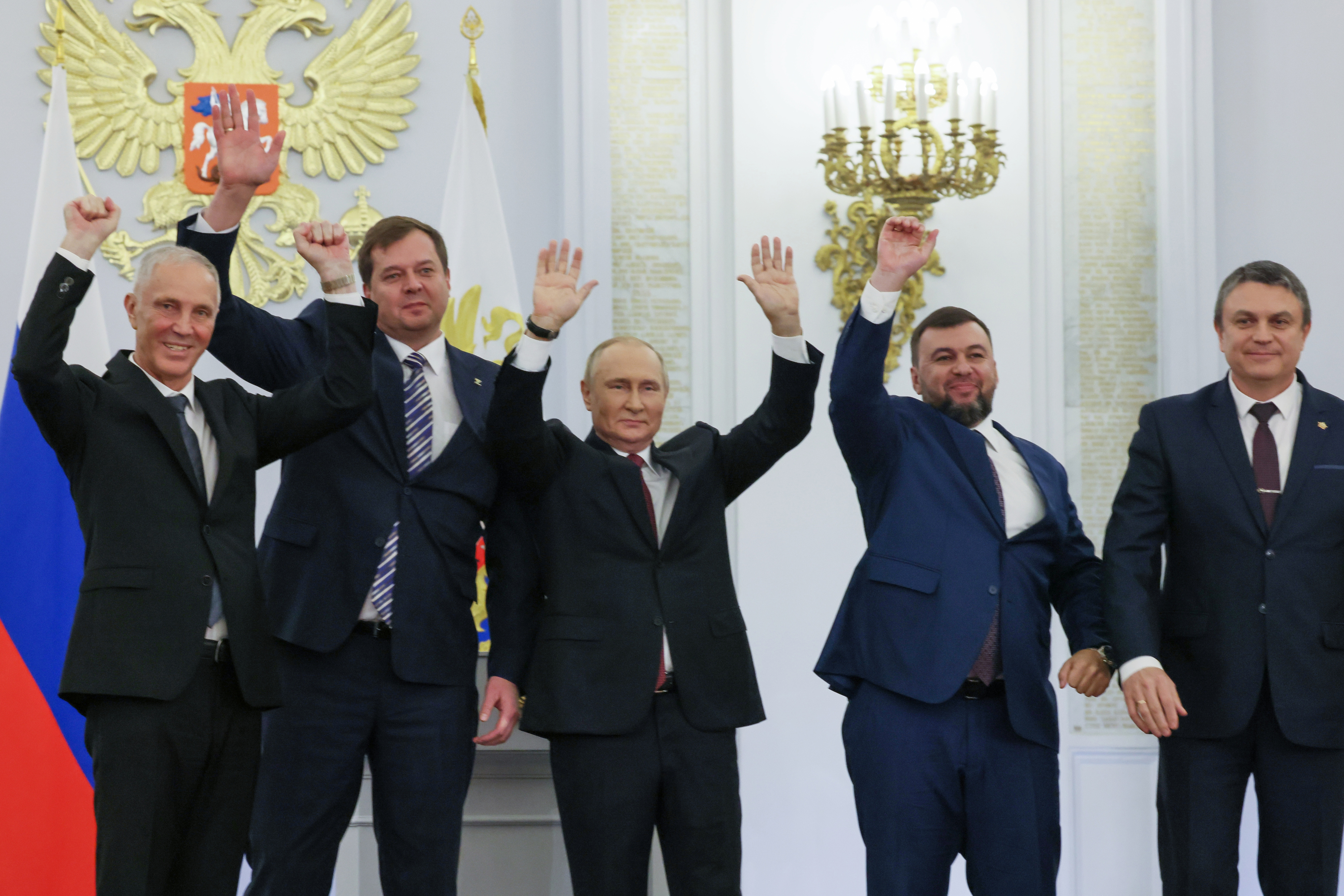 From left, Moscow-appointed head of Kherson Region Vladimir Saldo, Moscow-appointed head of Zaporizhzhia region Yevgeny Balitsky, Russian President Vladimir Putin, center, Denis Pushilin, the leader of the Donetsk People's Republic and Leonid Pasechnik, leader of self-proclaimed Luhansk People's Republic wave during a ceremony to sign the treaties for four regions of Ukraine to join Russia, at the Kremlin, Moscow, Friday.