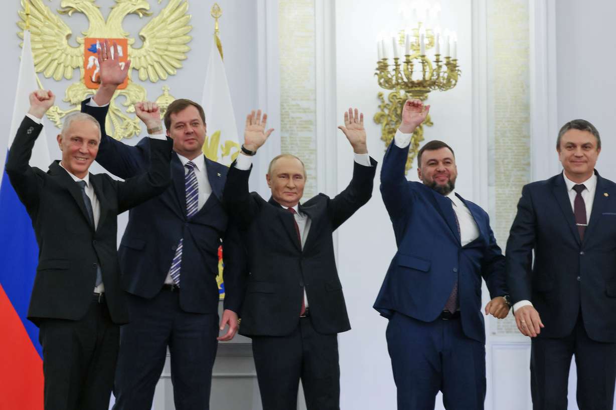 From left, Moscow-appointed head of Kherson Region Vladimir Saldo, Moscow-appointed head of Zaporizhzhia region Yevgeny Balitsky, Russian President Vladimir Putin, center, Denis Pushilin, the leader of the Donetsk People's Republic and Leonid Pasechnik, leader of self-proclaimed Luhansk People's Republic wave during a ceremony to sign the treaties for four regions of Ukraine to join Russia, at the Kremlin, Moscow, Friday.