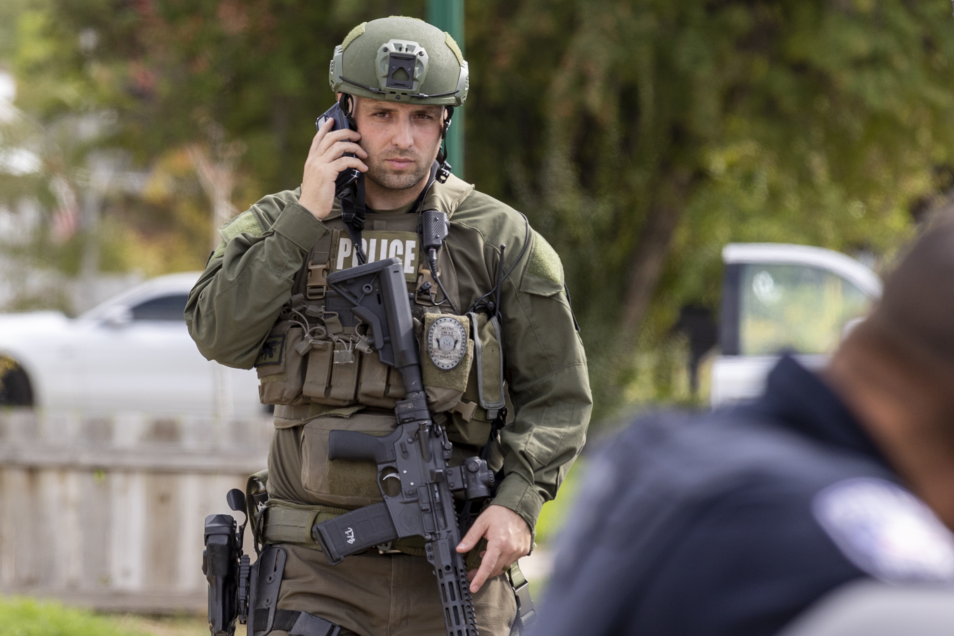 A SWAT officer walks while on the phone after a standoff in Orem on Thursday.