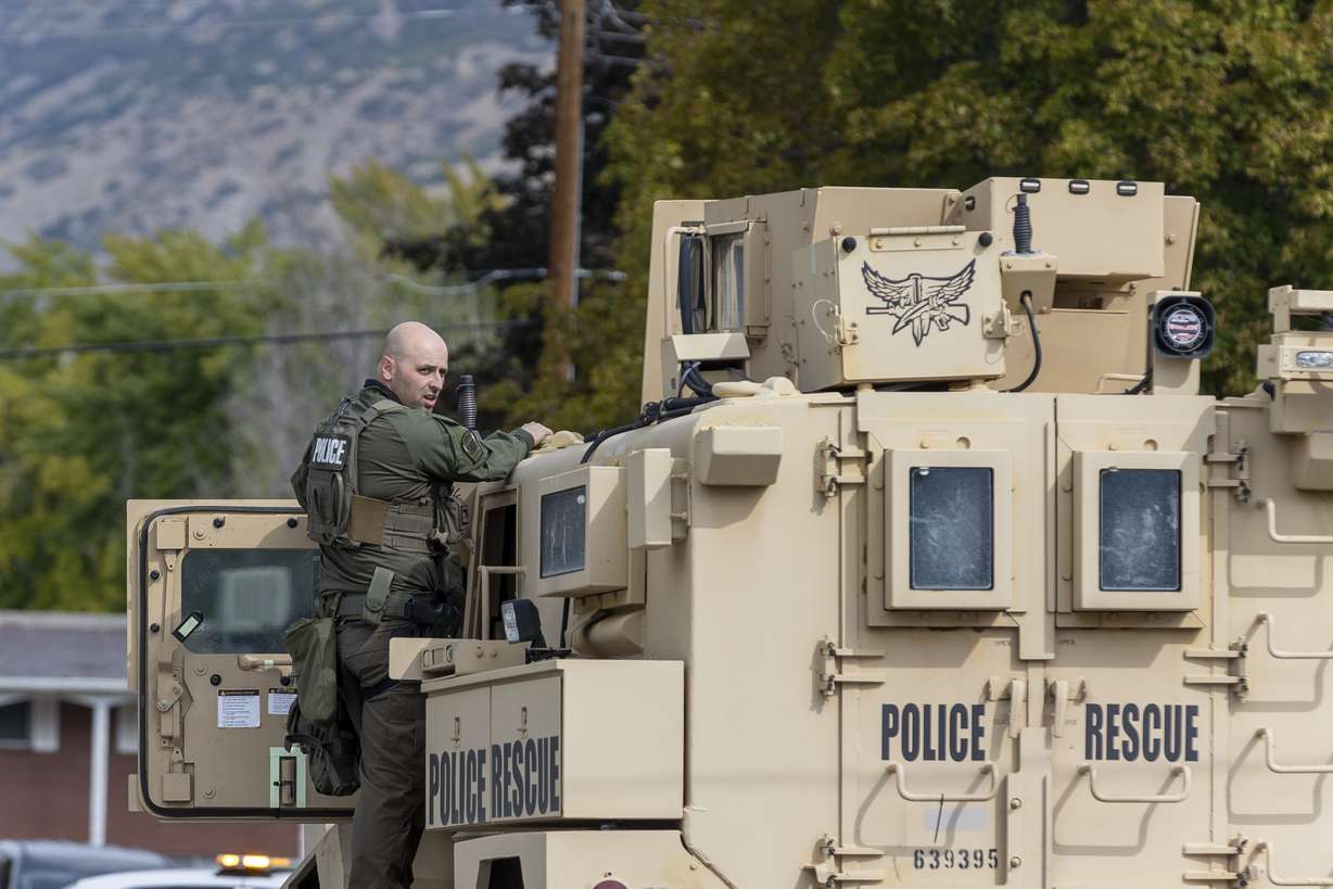 A SWAT officer stands on his armored vehicle after a standoff in Orem on Thursday.