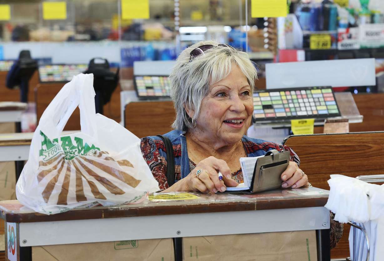 Jill Reid writes a check for her groceries at Reams Food Store in Sandy on Friday, Sept. 23.