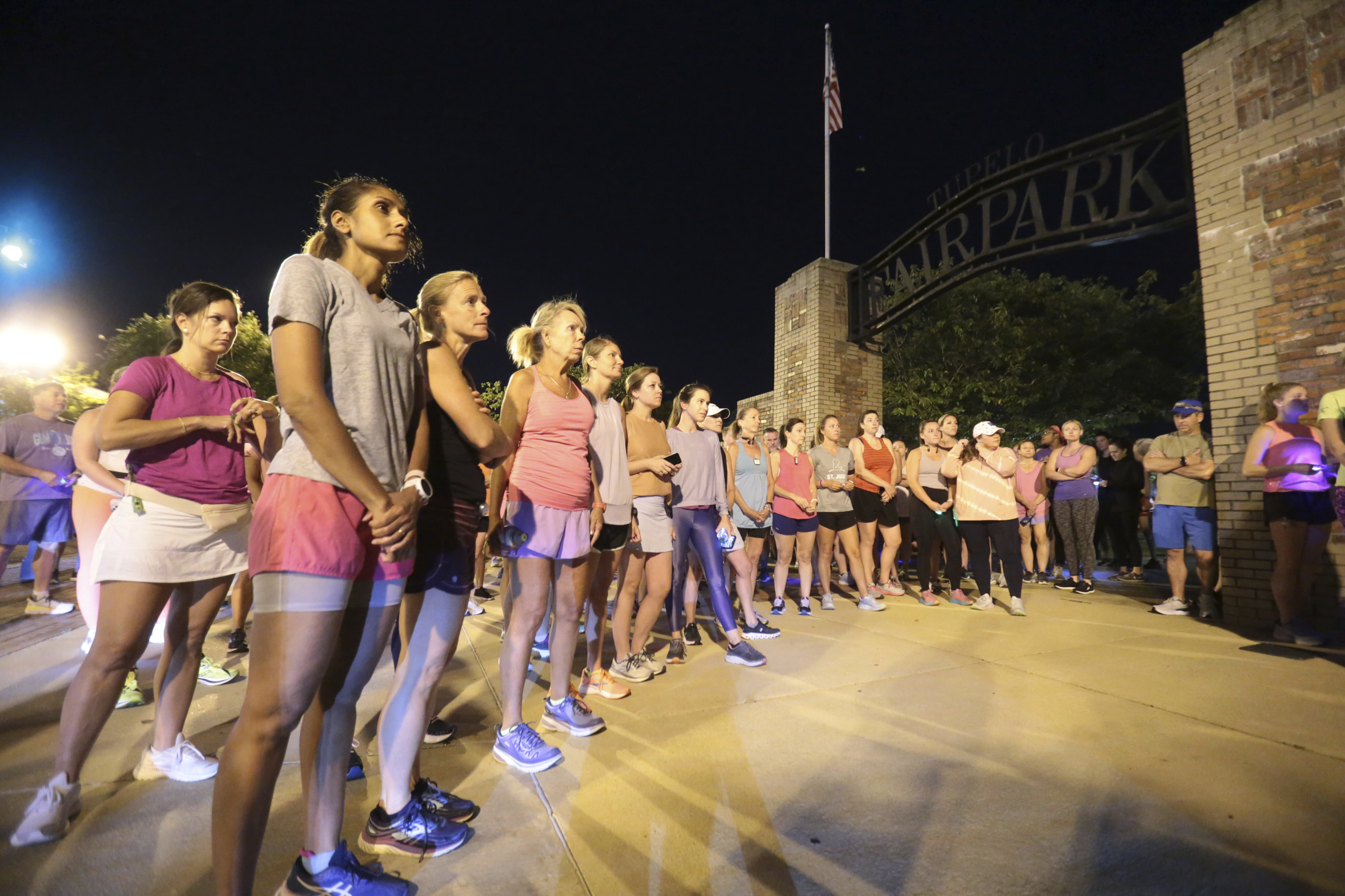 Members of the Tupelo Running Club and others gather for a moment of silence before they begin their "Liza's Lights" run Friday, Sept. 9, in Tupelo Miss., to remember Eliza Fletcher, who was abducted and murdered while she was running in the early morning hours in Memphis, Tenn. 