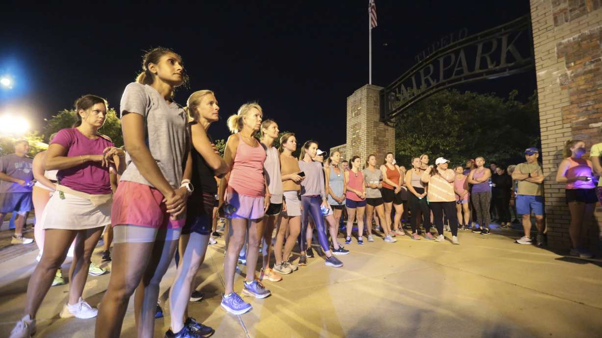 Members of the Tupelo Running Club and others gather for a moment of silence before they begin their "Liza's Lights" run Friday, Sept. 9, in Tupelo Miss., to remember Eliza Fletcher, who was abducted and murdered while she was running in the early morning hours in Memphis, Tenn.