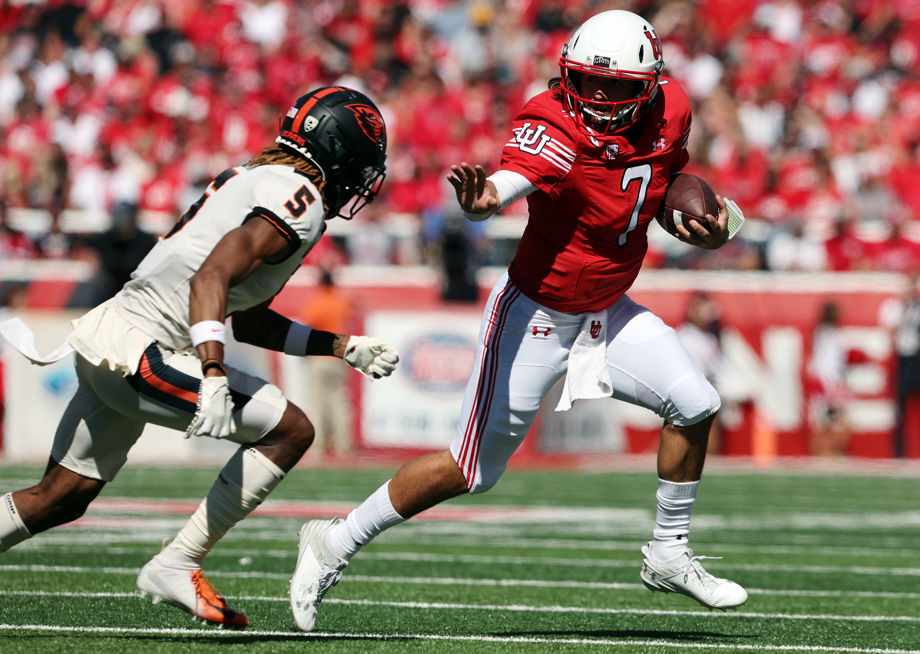 Utah Utes quarterback Cameron Rising (7) reaches out to stiff-arm Oregon State Beavers defensive back Alex Austin (5) during a run as Utah and Oregon State play at Rice Eccles Stadium in Salt Lake City on Saturday, Oct. 1, 2022.