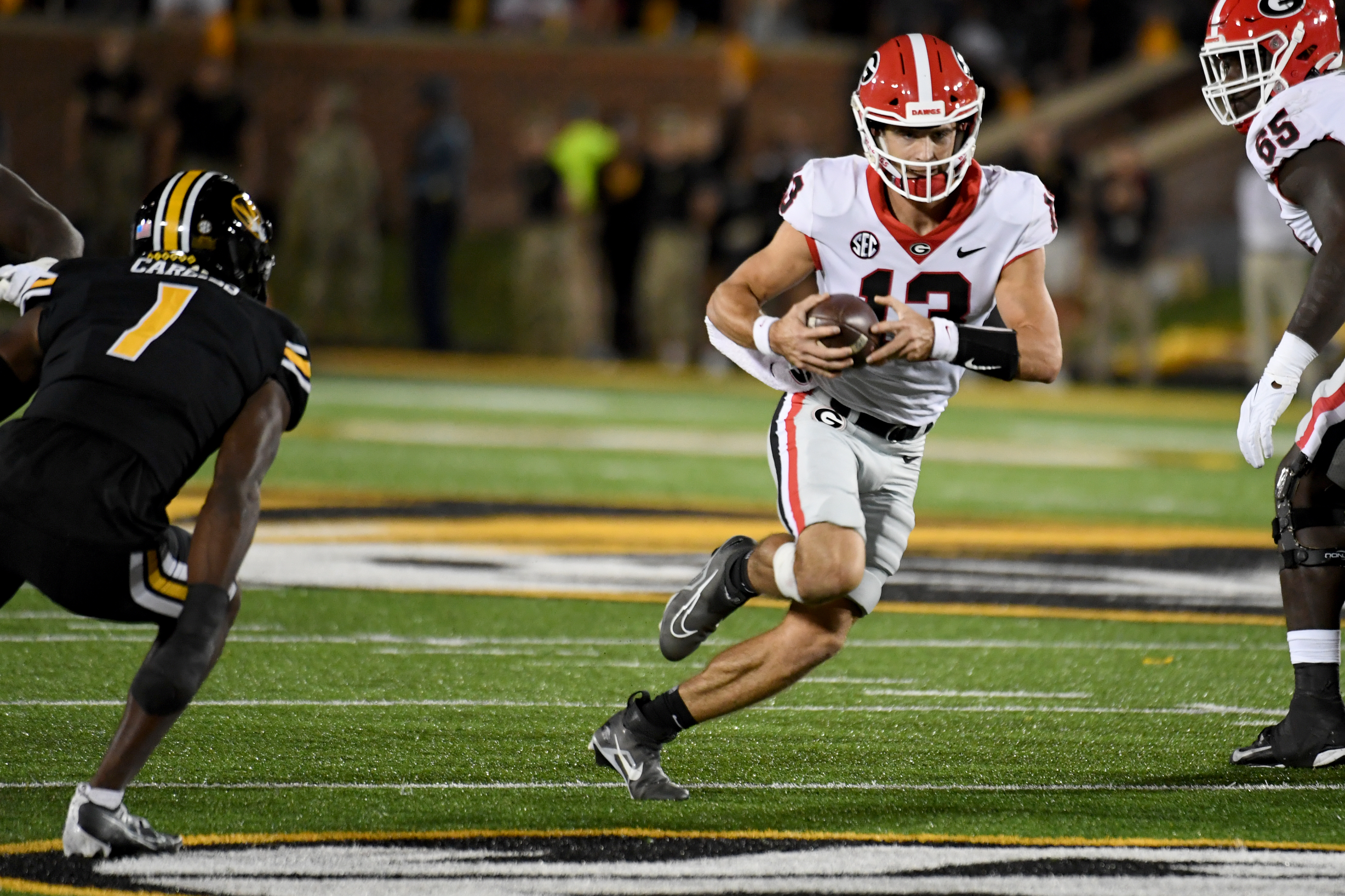 Georgia quarterback Stetson Bennett runs with the ball on a fake field goal attempt as Missouri defensive back Jaylon Carlies (10) defends during the first half of an NCAA college football game Saturday, Oct. 1, 2022, in Columbia, Mo. 