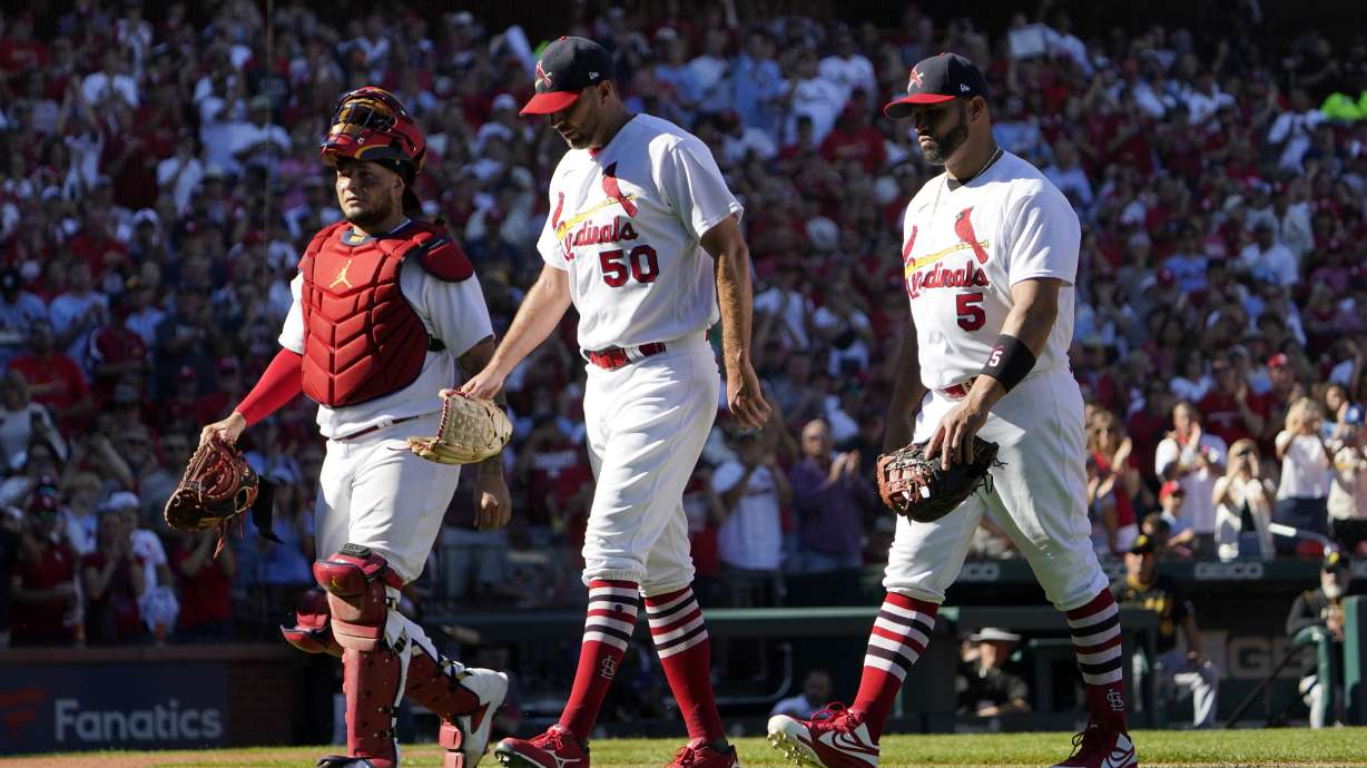 St. Louis Cardinals catcher Yadier Molina, left, starting pitcher Adam Wainwright (50) and first baseman Albert Pujols (5) walk off the field together as they are all removed at the from a baseball game against the Pittsburgh Pirates same time in the fifth inning Sunday, Oct. 2, 2022, in St. Louis.