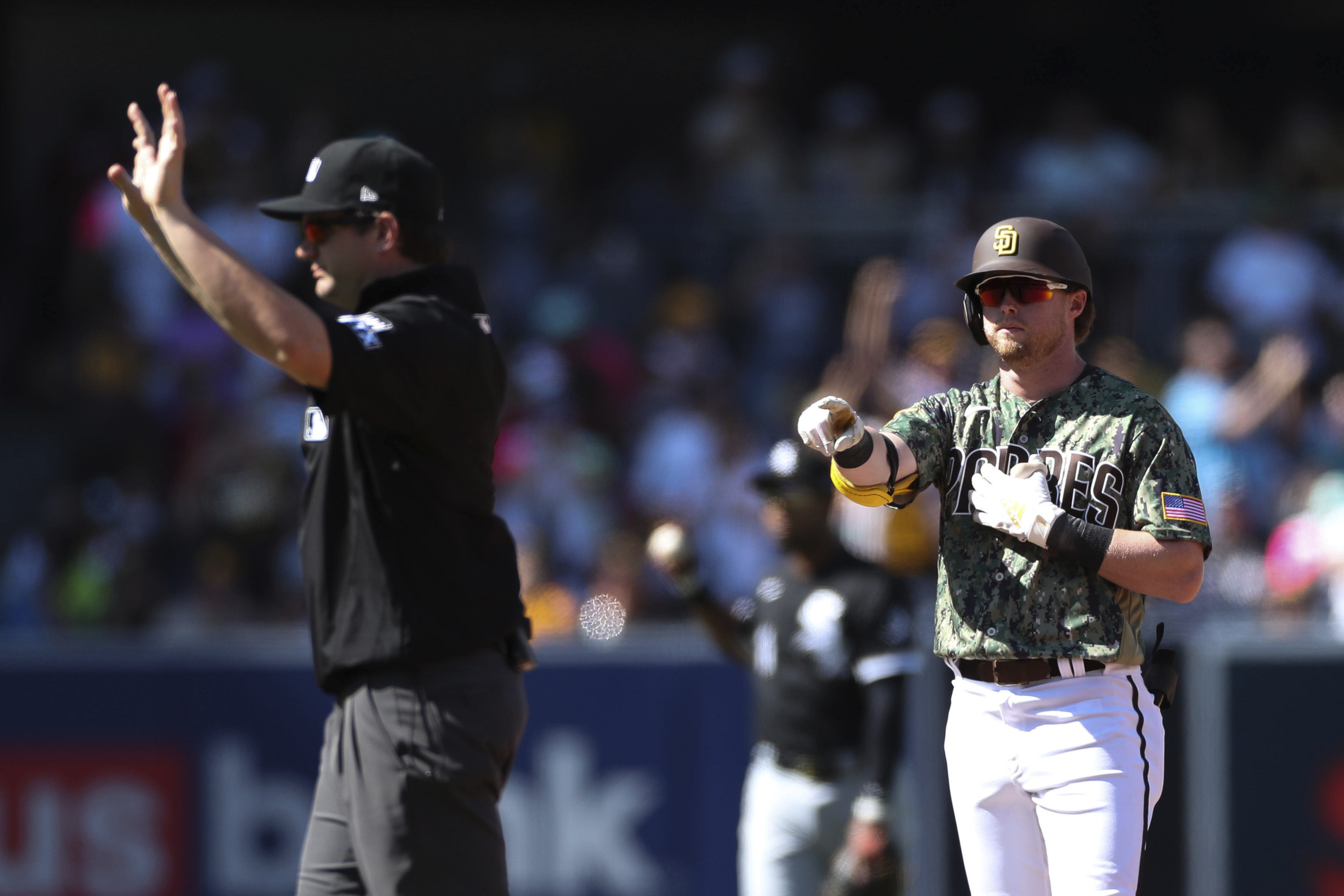 San Diego Padres' Jake Cronenworth, right, points toward the dugout after hitting a double against the Chicago White Sox as umpire Adam Beck calls time in the fourth inning a baseball game Sunday, Oct. 2, 2022, in San Diego. 