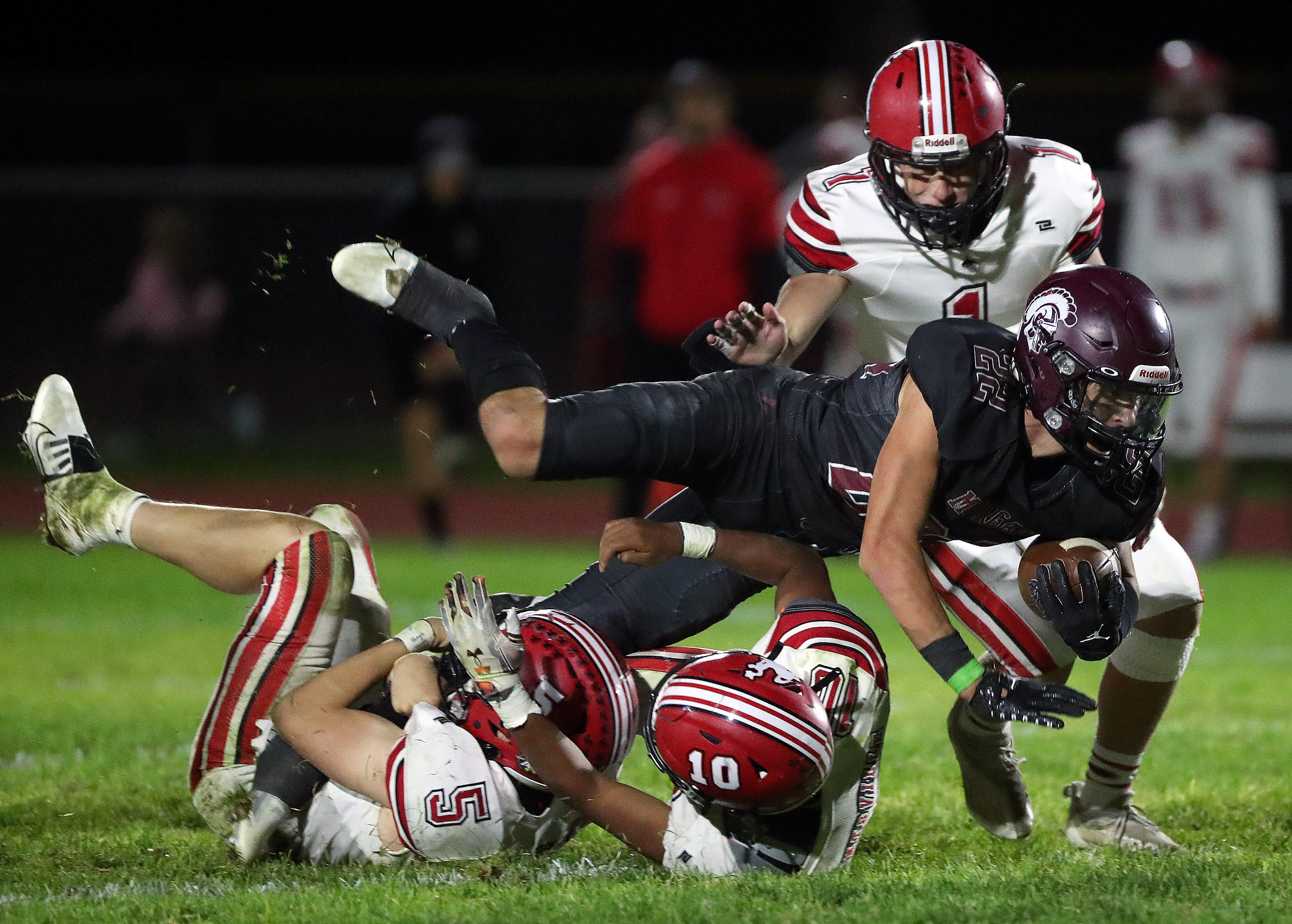 Morgan’s Gunnar Lish falls over Grantsville’s Gabe Mouritsen (5) and Lee Maile (10) as Griffin Kimber (1) rushes in to complete the tackle during a varsity football game at Morgan High School in Morgan on Friday, Sept. 30, 2022. Morgan won 38-20.
