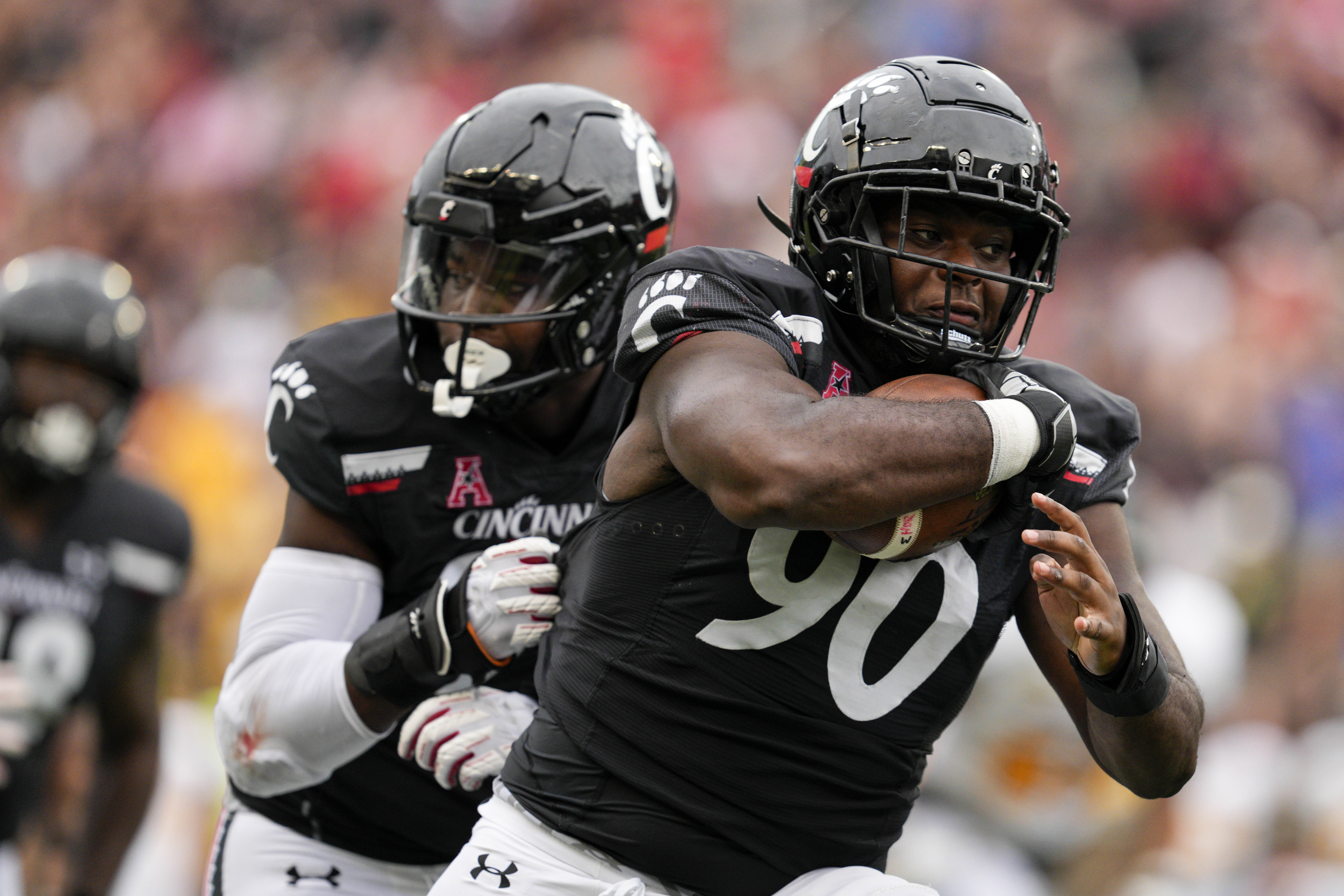 Cincinnati defensive lineman Jabari Taylor (90) runs for a touchdown after recovering a fumble during the second half of an NCAA college football game against Kennesaw State, Saturday, Sept. 10, 2022, in Cincinnati. 