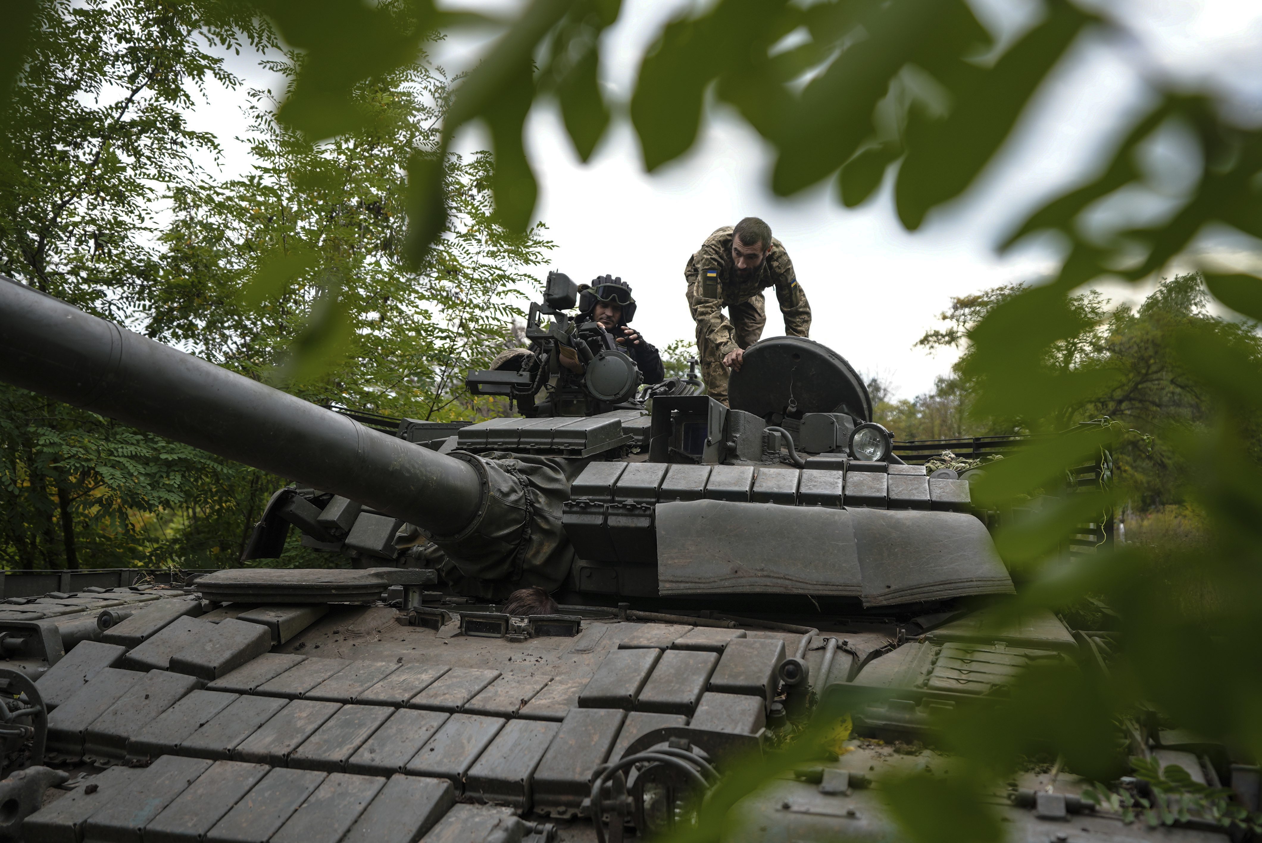 Ukrainian servicemen sit on T-80 tank that they claimed had been captured from the Russian army in Bakhmut, Ukraine, Sunday.