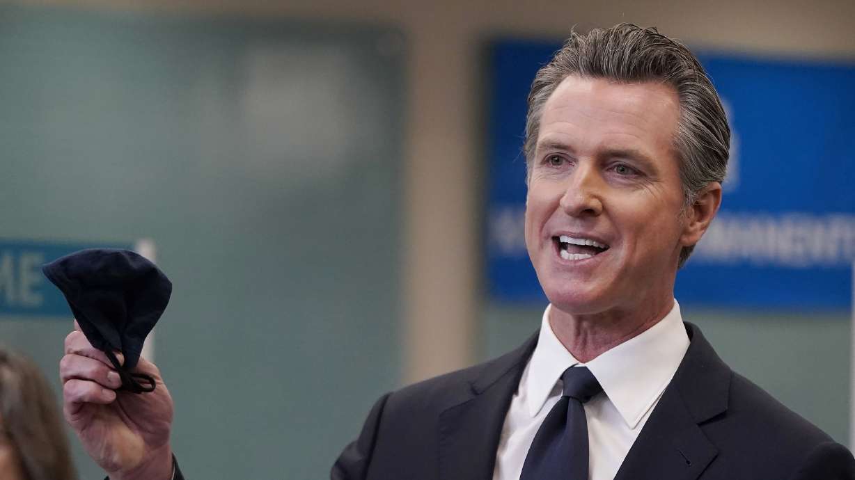 California Gov. Gavin Newsom holds a face mask while speaking at a news conference in Oakland, California, on July 26, 2021. Doctors in California who spread misinformation about COVID-19 to their patients now face losing their license to practice medicine.